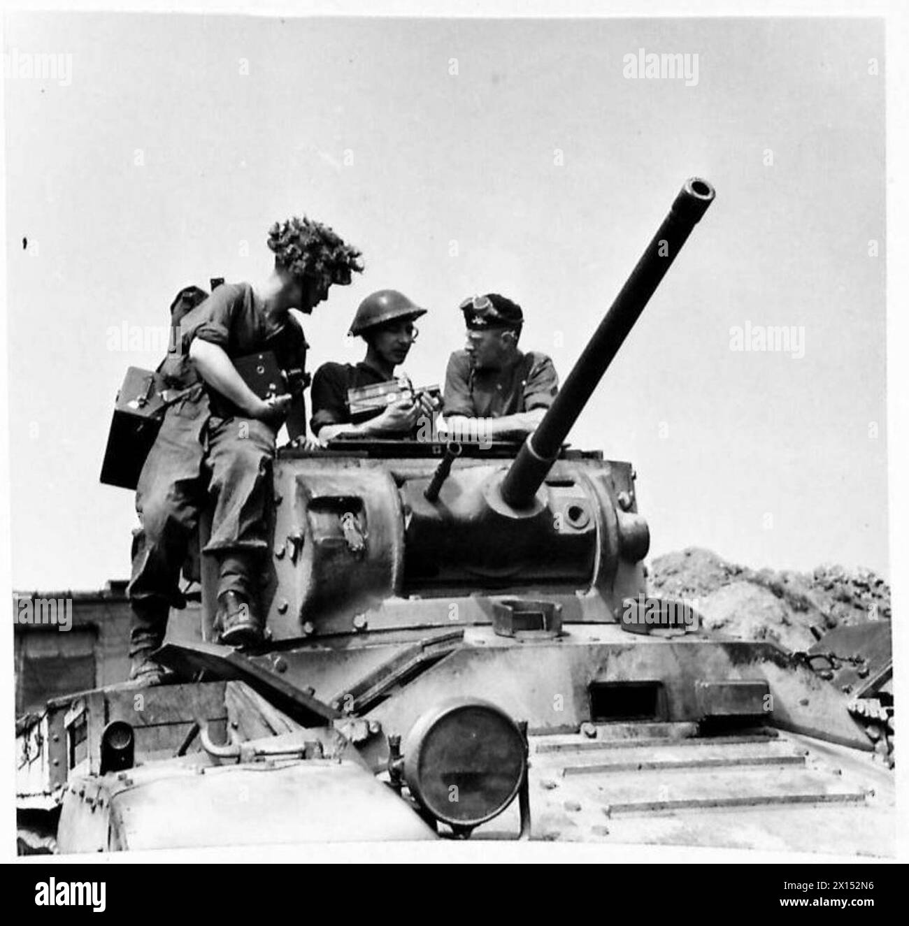 Army Film Unit cameramen discuss filming plans with a tank crew during ...