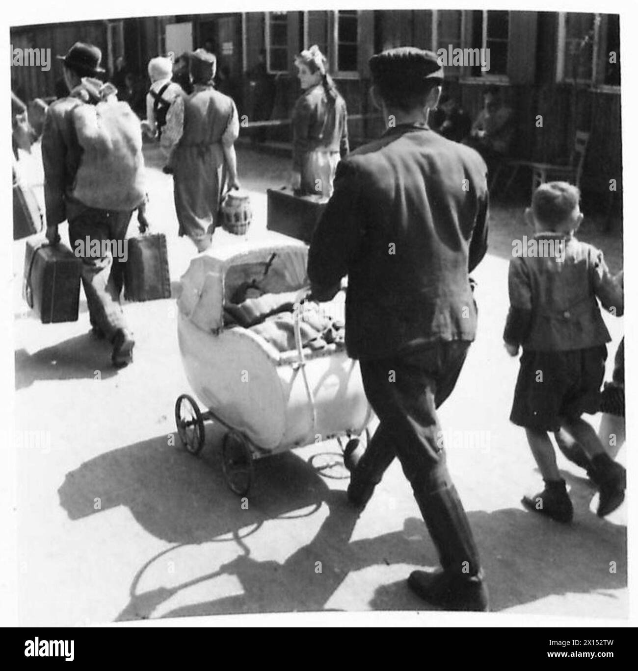 DISPLACED PERSONS AND REFUGEES IN GERMANY - Aleksy Waszczuk and his family arriving at the camp. His little son Leon in on the right. The Displaced Persons camp within the grounds of Hamburg Zoo was build by the Blohm & Voss company during WWII to house the forced labourers that worked in their factory. The camp was taken over by the British on 5 May 1945 and quickly given over as an arrivals centre for displaced persons. On arrival displaced persons were organised into groups of 50 for processing through the reception centre. They were dusted with anti-louse powder and given a registration ca Stock Photo