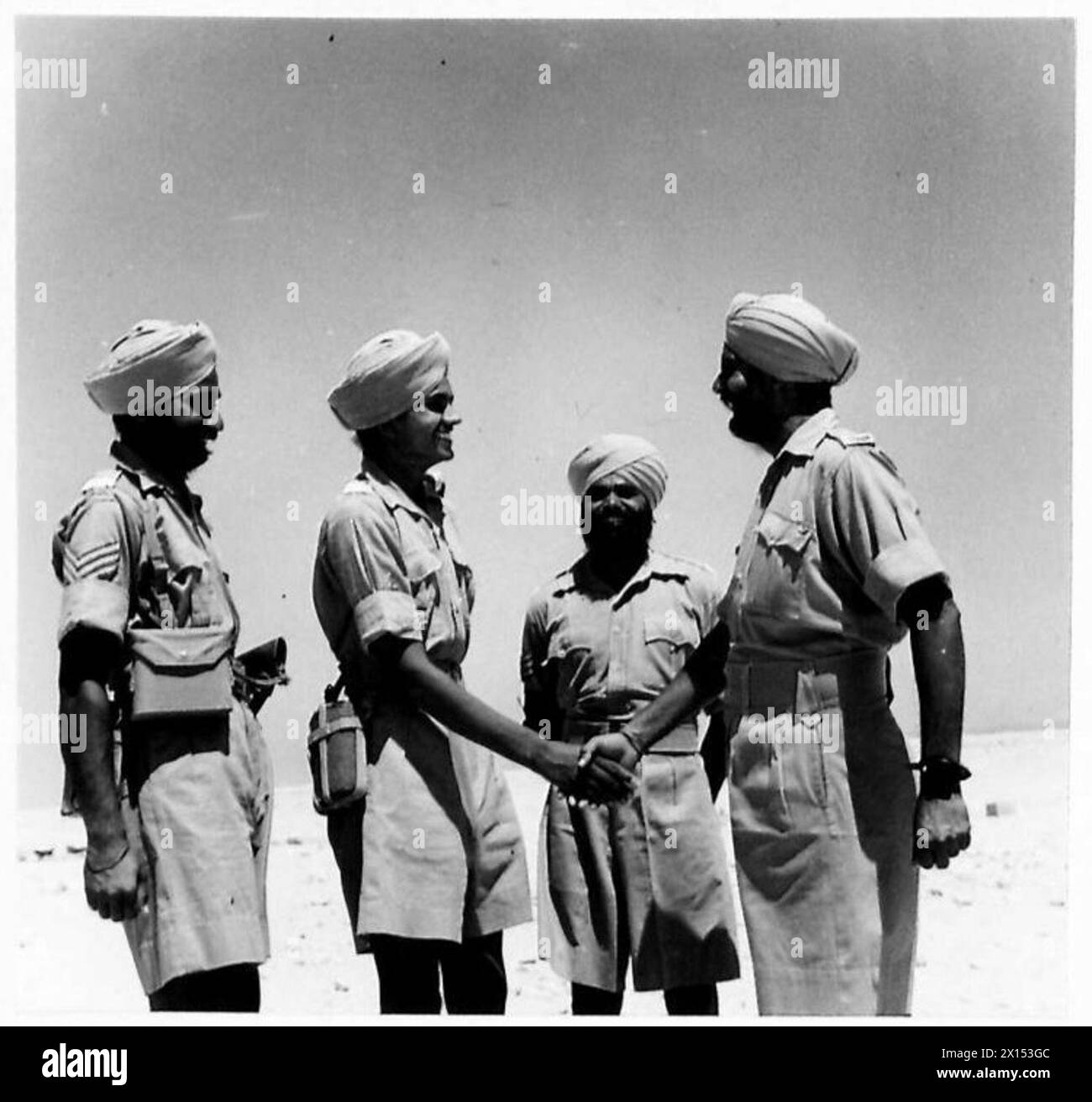 GALLANT SIKH AWARDED THE I.D.S.M. - Receiving congratulations from other men of the regiment British Army Stock Photo