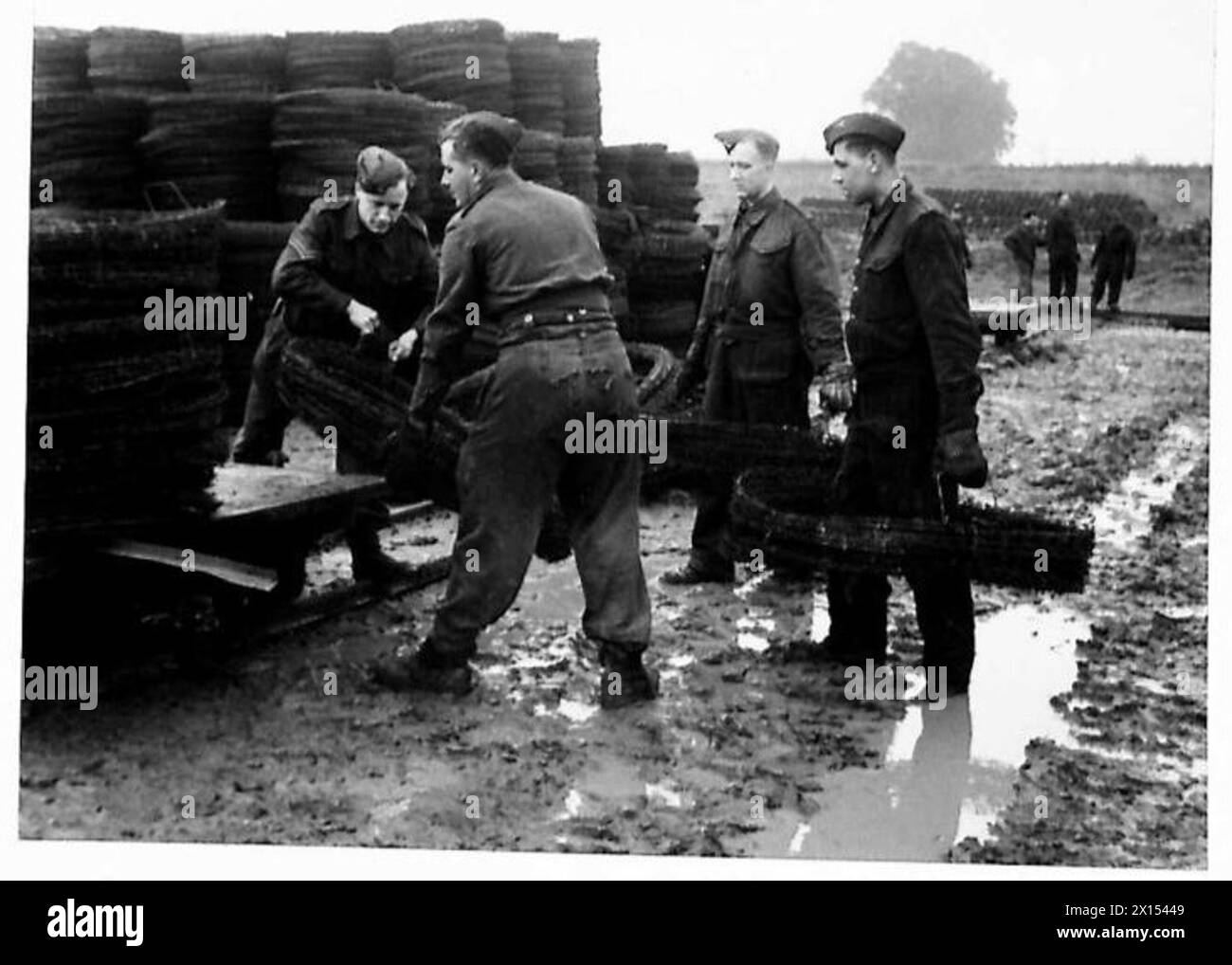 THE PIONEER CORPS - Carrying rolls of wire through the mud for stacking ...