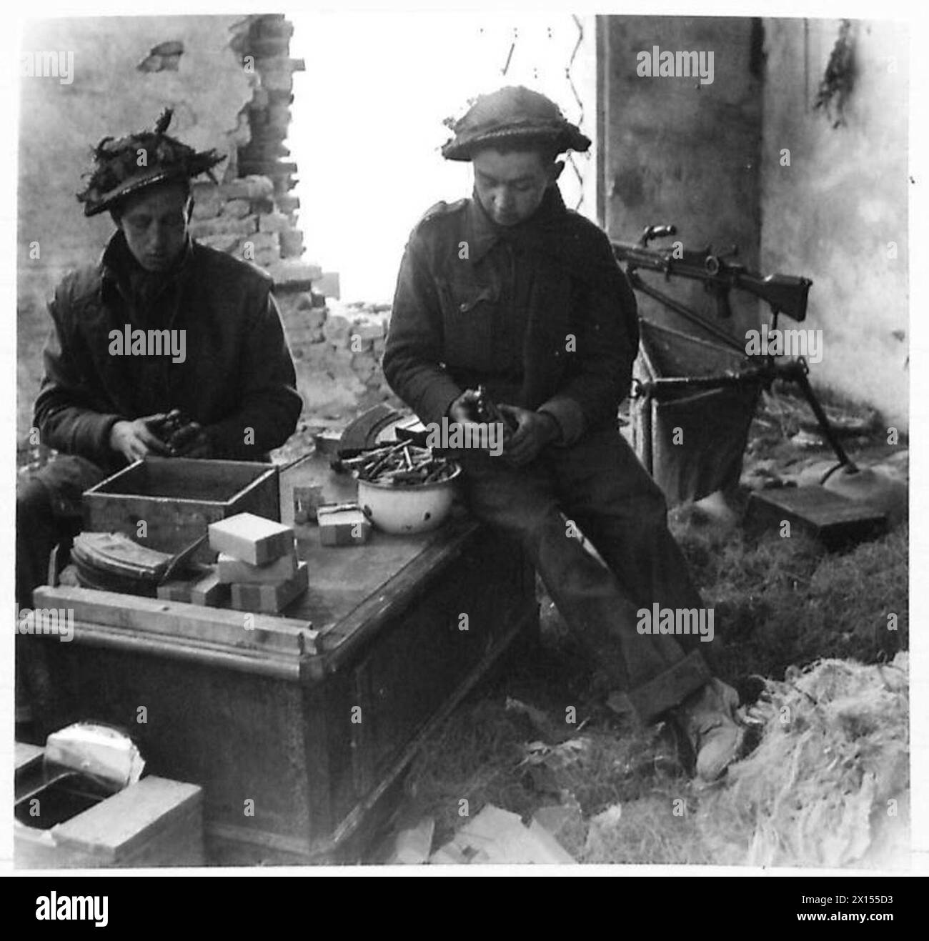 THE BRITISH ARMY IN NORTH AFRICA, SICILY, ITALY, THE BALKANS AND AUSTRIA 1942-1946 - Rfn. W.Wright of Blackburn and Rfn. L. Bell of Stratford, London, reload Bren gun magazines ready for another shoot against enemy positions near the River Senio British Army Stock Photo