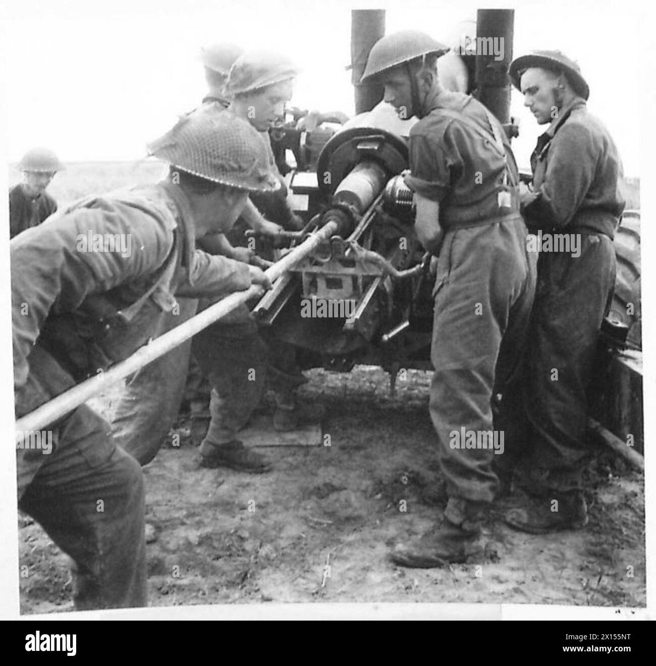 A 100-pound shell is loaded into the breech of a 5.5-inch medium gun at ...