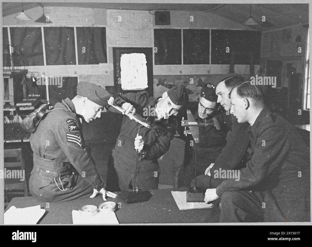Air gunners study the armament of a model German aircraft during the Battle of the Bay of Biscay in 1942, demonstrating RAF training and tactical analysis. Stock Photo