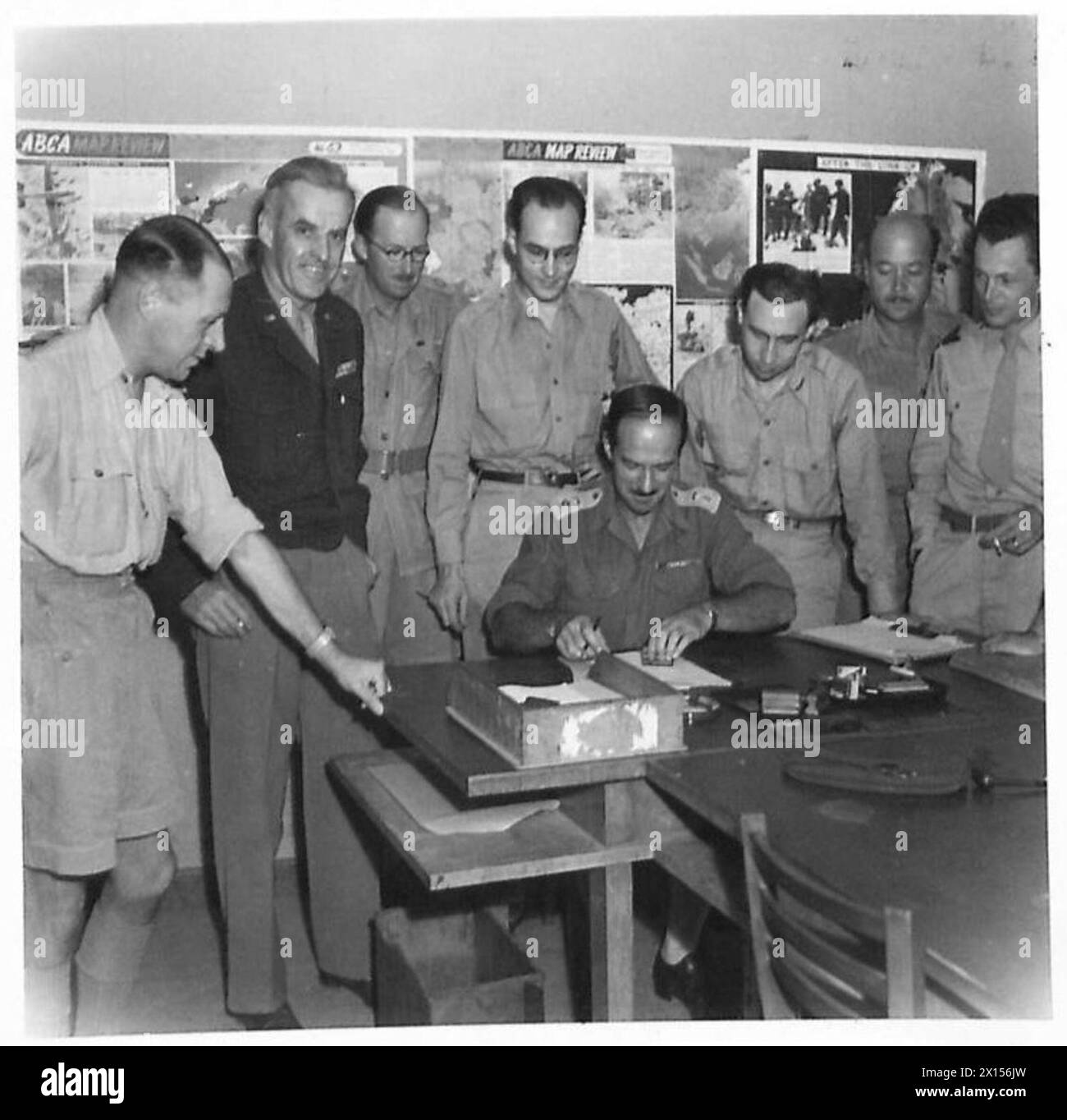 THE END OF CENSORSHIP IN ITALY - Lieut. Colonel Hayden, Chief Censor, uses the 'blue pencil' for the last time. Looking on are his staff; left to right:- Sqn.Ldr. A. Payler, Chief Air Censor Brigadier A.V. McChrystal late Chief Information, News & Censorship Section Major P.B. Lowe, Mr. J.E. Murray (U.P.) Mrs. G. Bria (A.P.) Major R. Parish, and Mr. Winston Burdett of C.B.S British Army Stock Photo