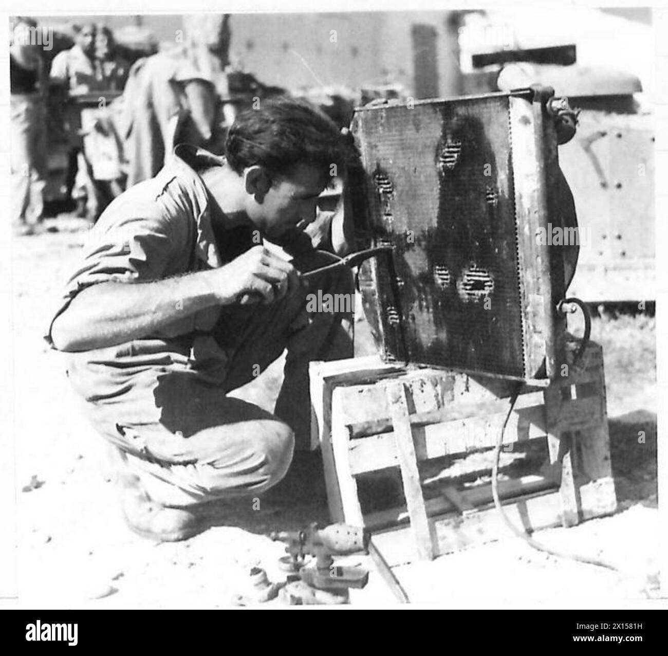 EIGHTH ARMY : GREEK R.E.M.E.WORKSHOPS - Cpl. N. Nitis of Alexandria, soldering a leak in a radiator British Army Stock Photo