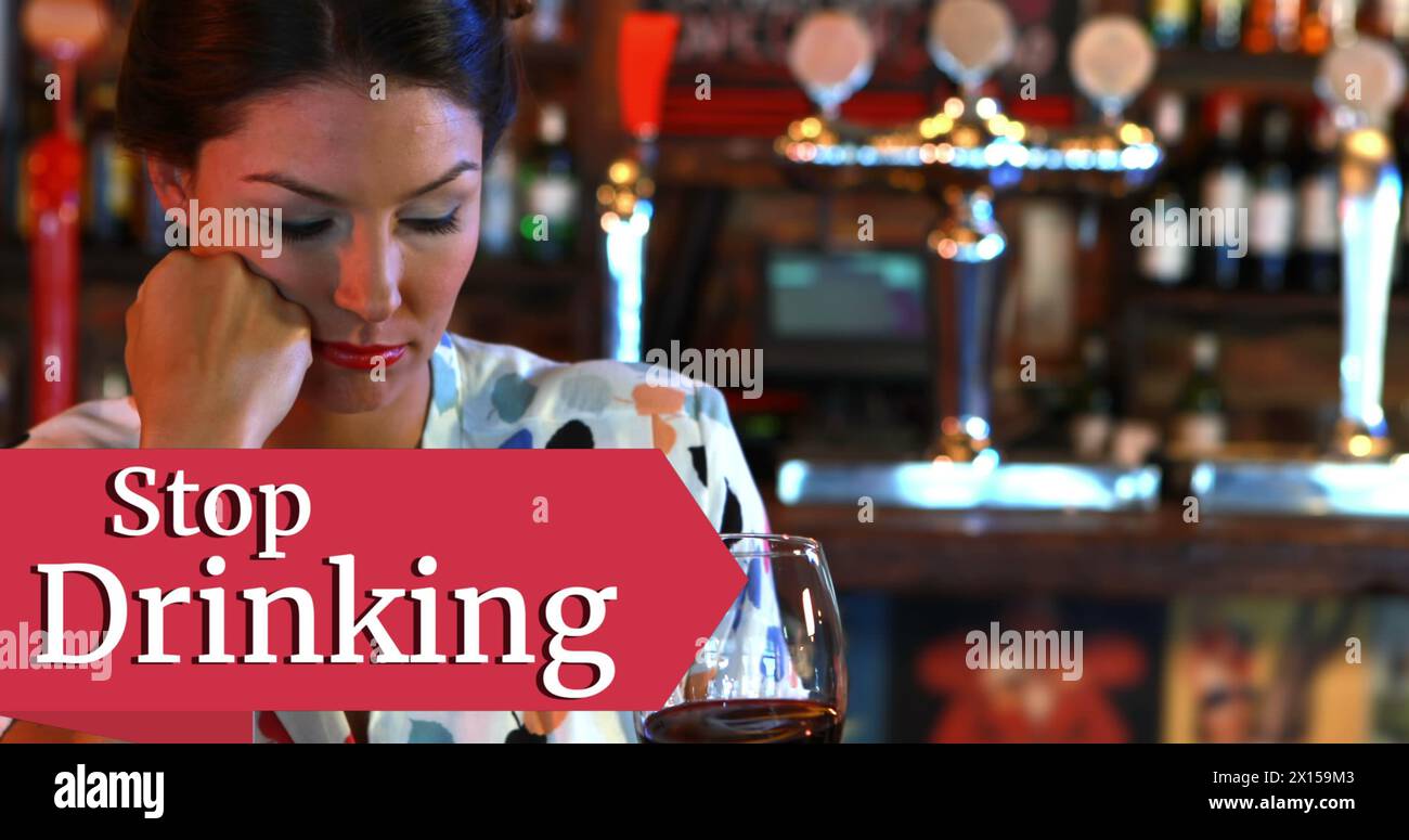Image of stop drinking text over caucasian woman in bar Stock Photo