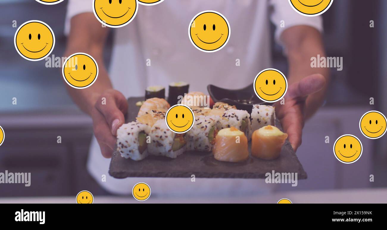 Image of emoji icons over diverse chef with sushi Stock Photo