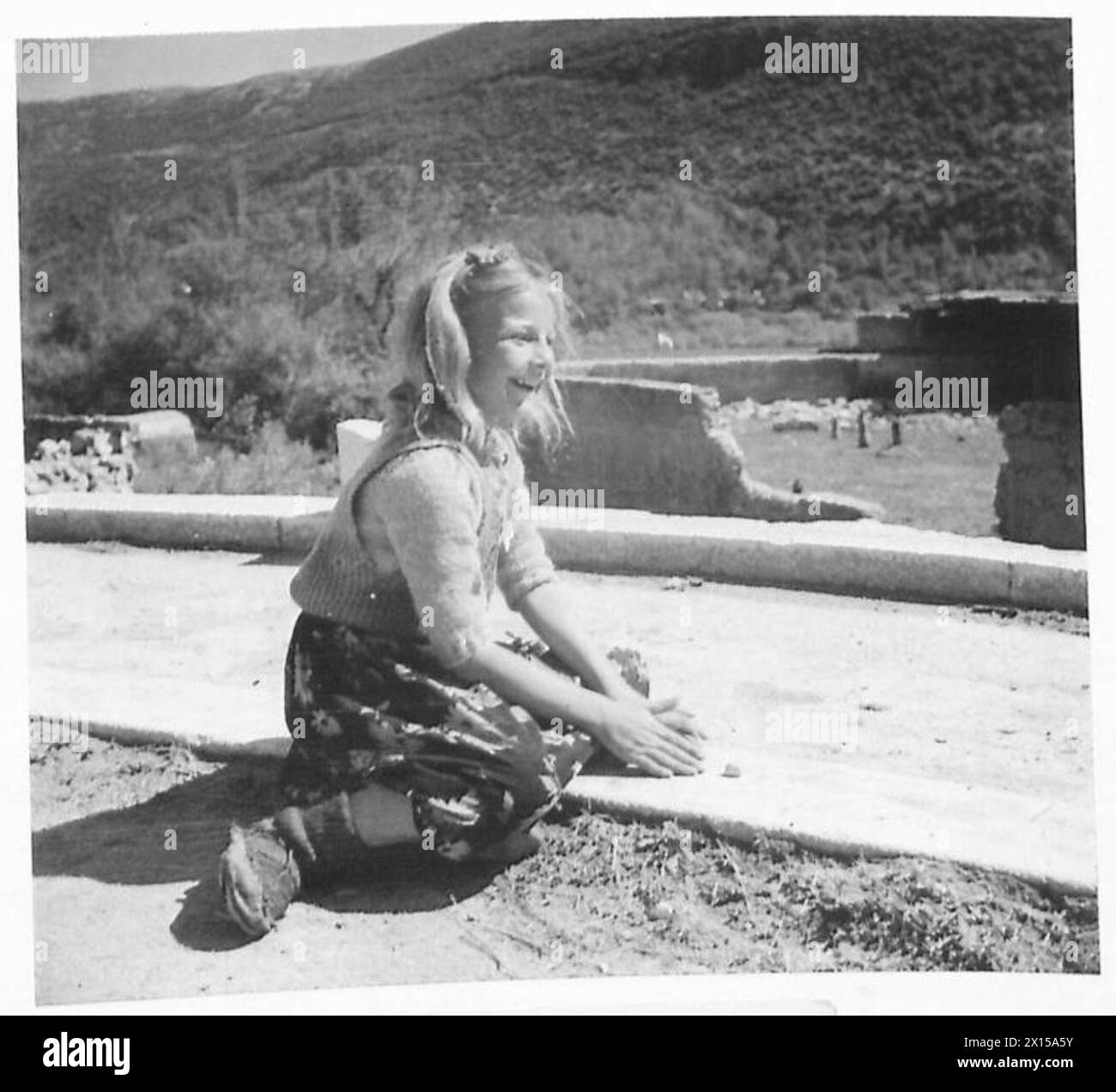 YUGOSLAVIA : LIFE IN THE BOSNIAN VILLAGE OF DRVAR - Even here the children play the games that English and American boys and girls know. This young girl is playing 'Dabs' or 'Five Stones' as we know it British Army Stock Photo