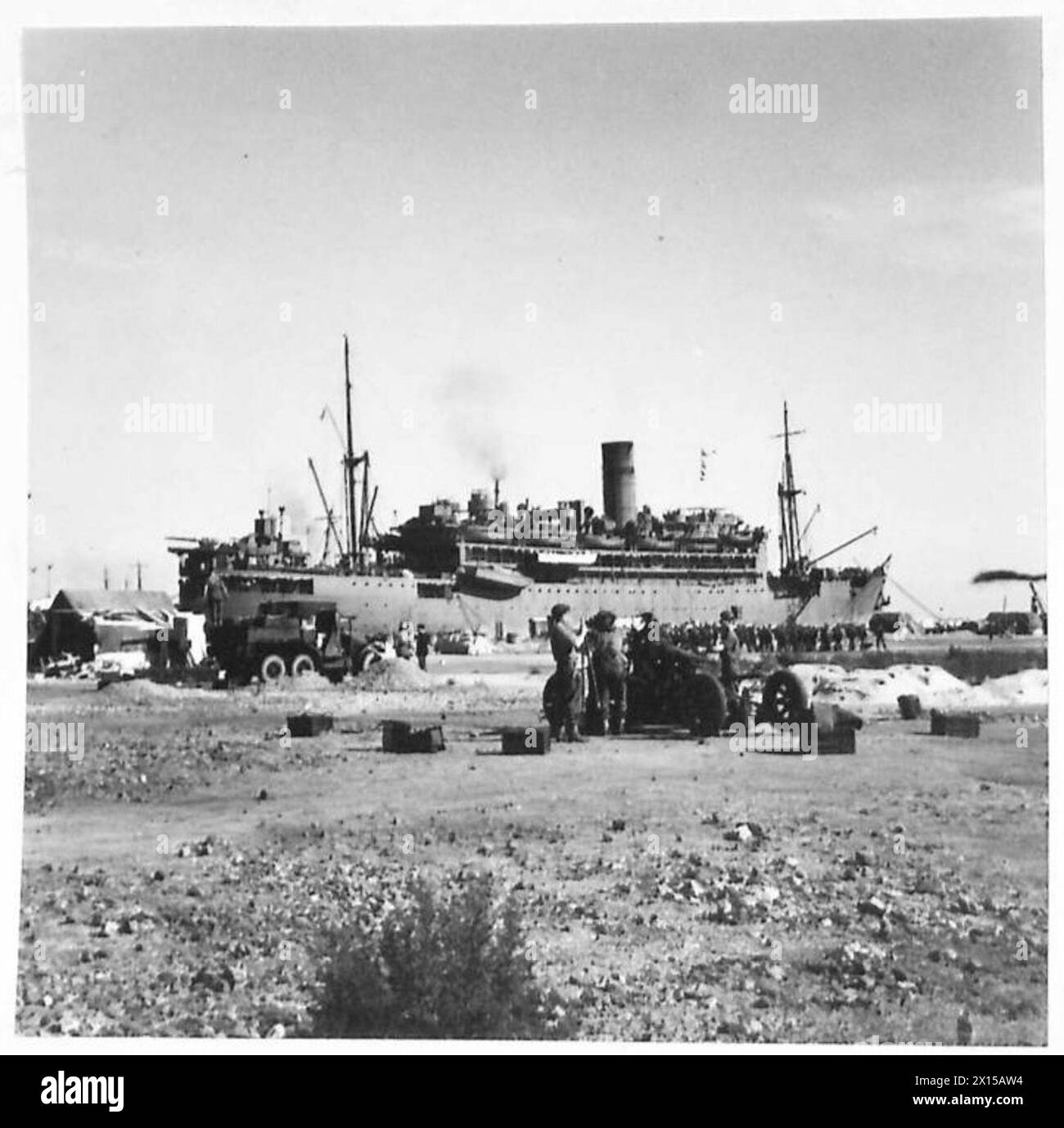 THE OPERATION TORCH, NOVEMBER 1942 - Troops of the US 34th Infantry Division disembarking from a Royal Navy troopship docked at captured Algiers, 9 November 1942. Note gunners of the British 78th Infantry Division setting up their Bofors 40 mm anti-aircraft gun in the foreground Royal Navy, US Army, British Army, British Army, 78th Infantry Division Stock Photo