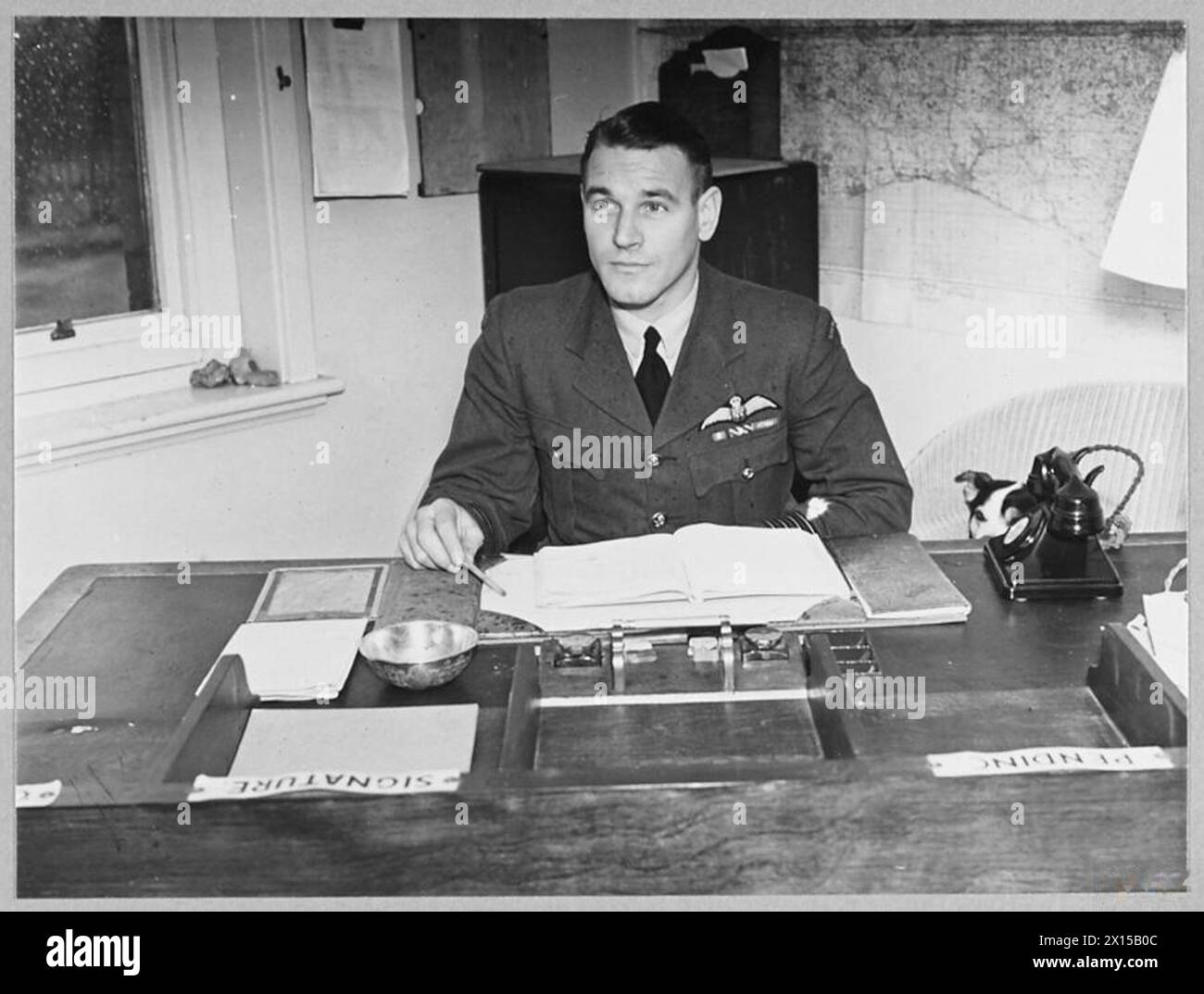 BRITAIN'S ACE FIGHTER PILOT TAKES OVER COMMANDOF A CRACK FIGHTER STATION - 8103 Group Captain Malan at his desk Royal Air Force Stock Photo