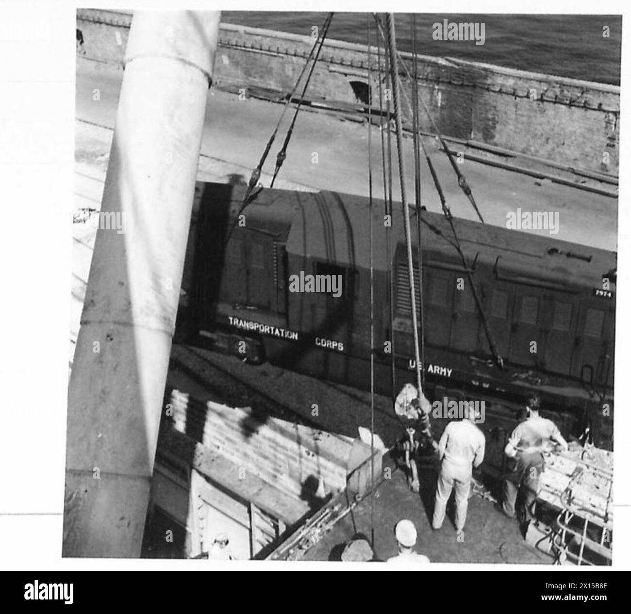 PHOTOGRAPHS OF PREFABRICATED PORT, ETC. - Lowering Diesel loco onto siding by ship's derrick , British Army, 21st Army Group Stock Photo
