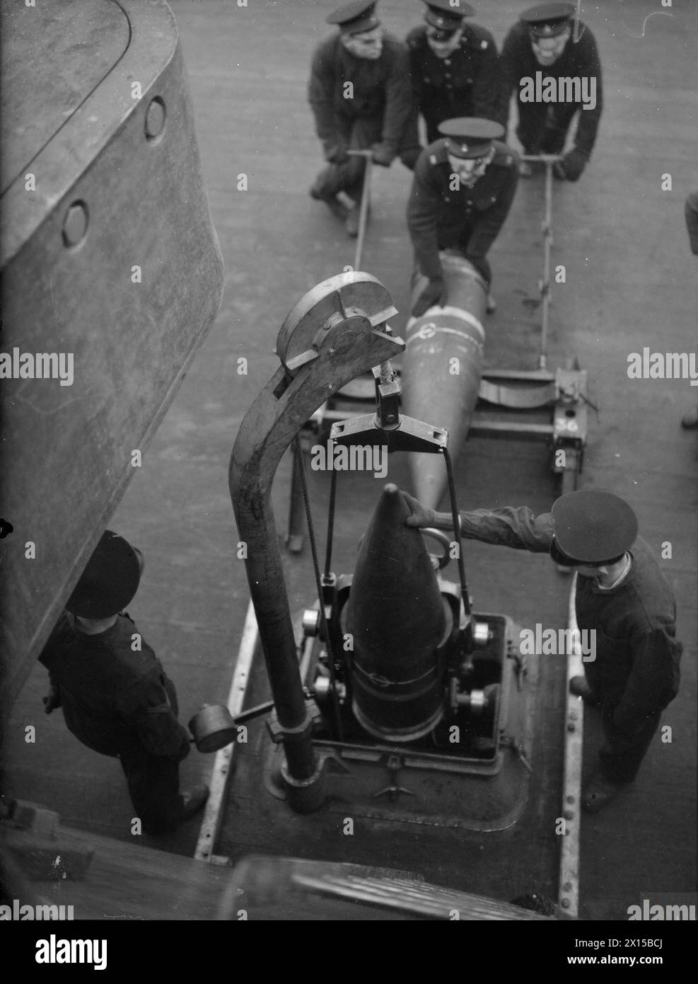 HMS KING GEORGE V GETS HER AMMUNITION QUOTA. 1941, ON BOARD THE BATTLESHIP IN PORT. - Royal Marines lowering the shells for their turret to the shell room, five decks below Stock Photo