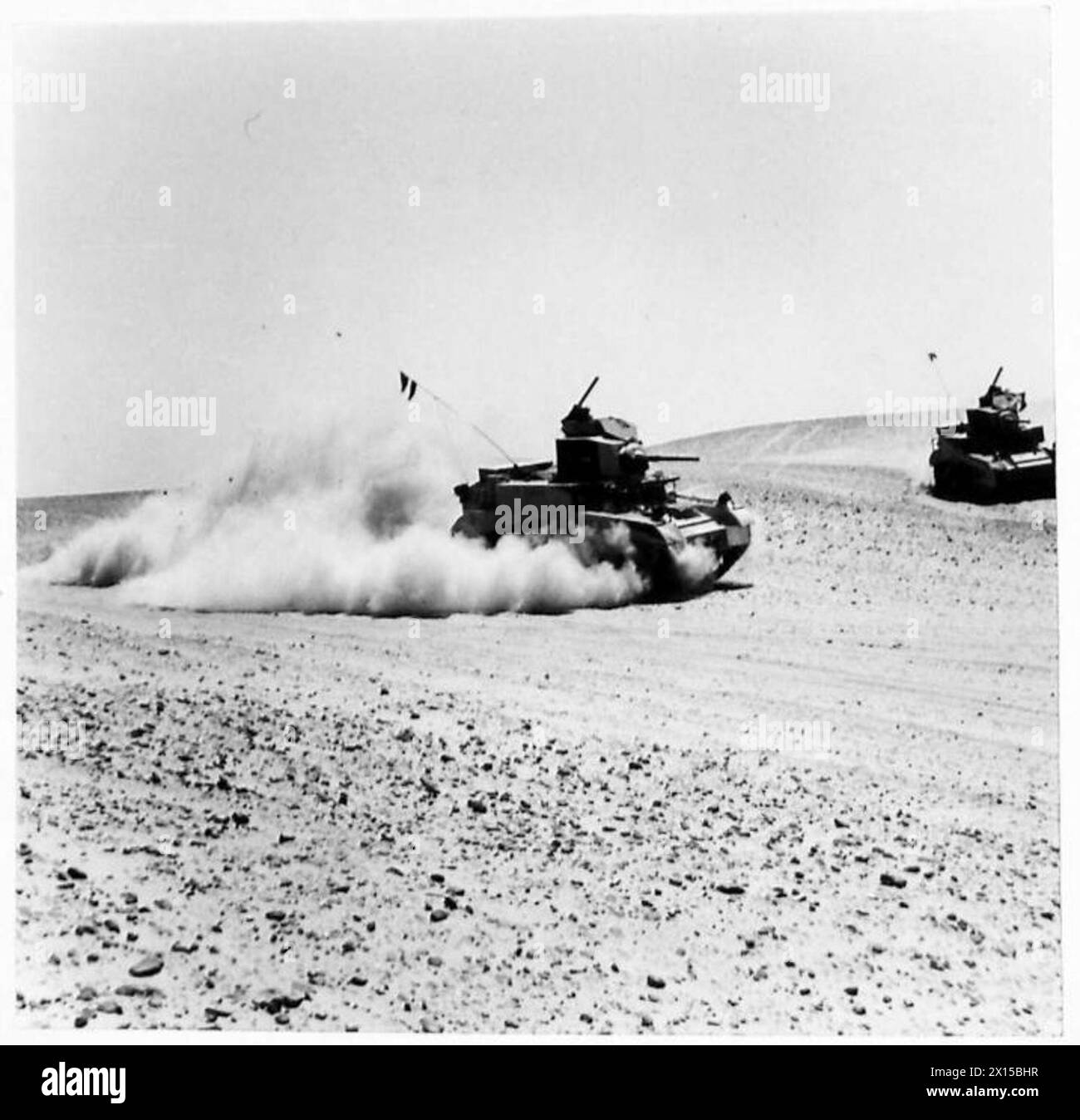A FAMOUS CAVALRY REGIMENT TRY OUT THEIR NEW AMERICAN TANKS - Kicking up the durst in the desert! The drivers of the new American tanks were quickly at the controls and were seen streaking across the desert, putting the tanks under severe tests British Army Stock Photo
