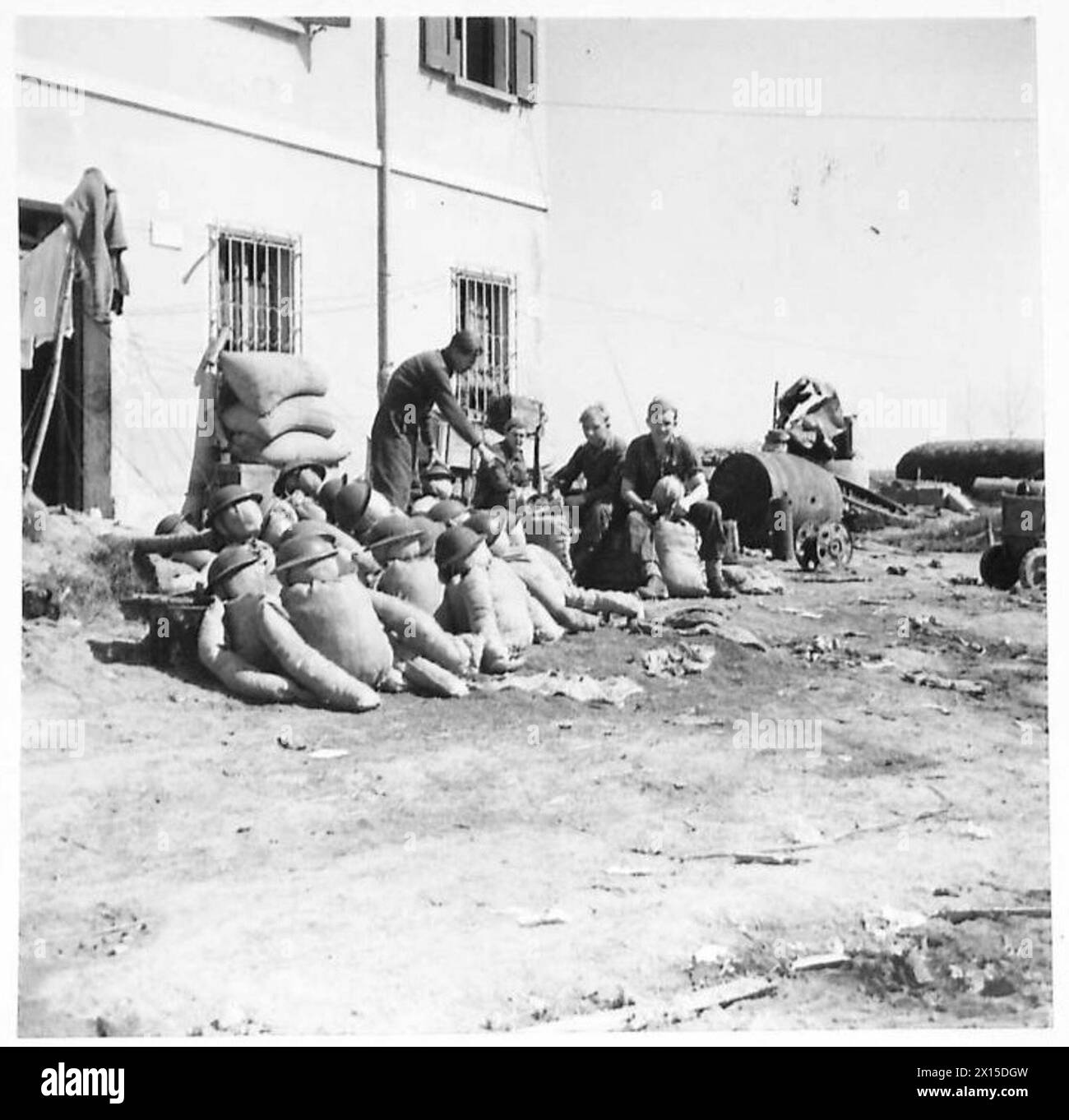 EIGHTH ARMY : COMMANDO BRIGADE IN ACTION - A few Marines of No.40 Commando busy making dummies of sandbags and straw for operational purposes. TSM J. Parkin of Cardiff gives advice to L/Cpl. L. Ramshaw of Barnsley, Yorks, and Marine Spanner of Staines, Middx British Army Stock Photo