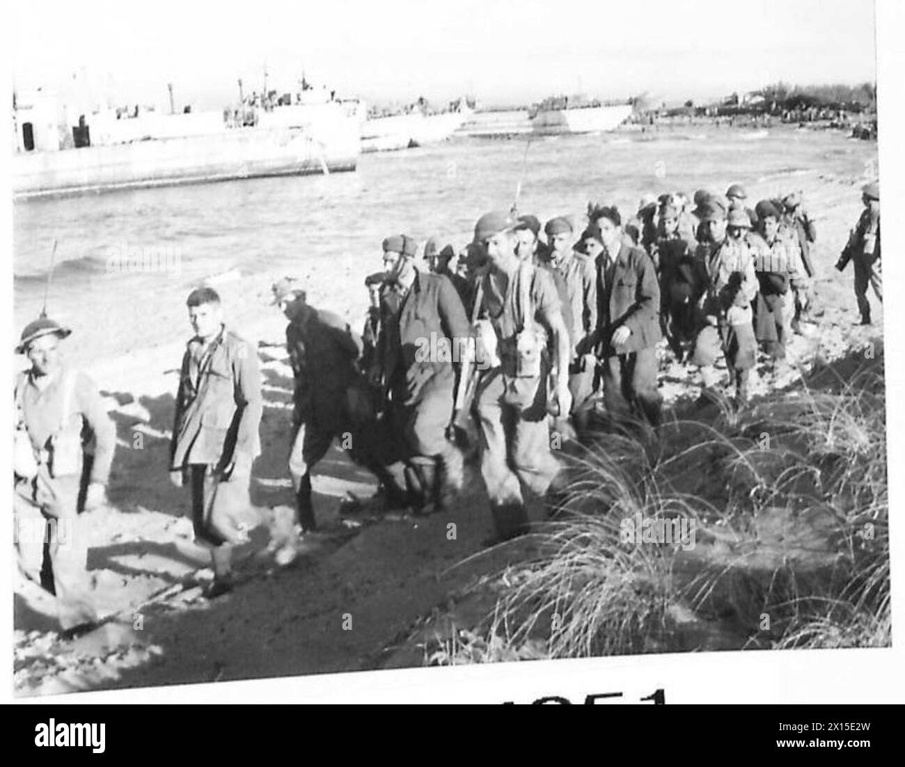 A prisoner is marched along the beach by British Army personnel during ...