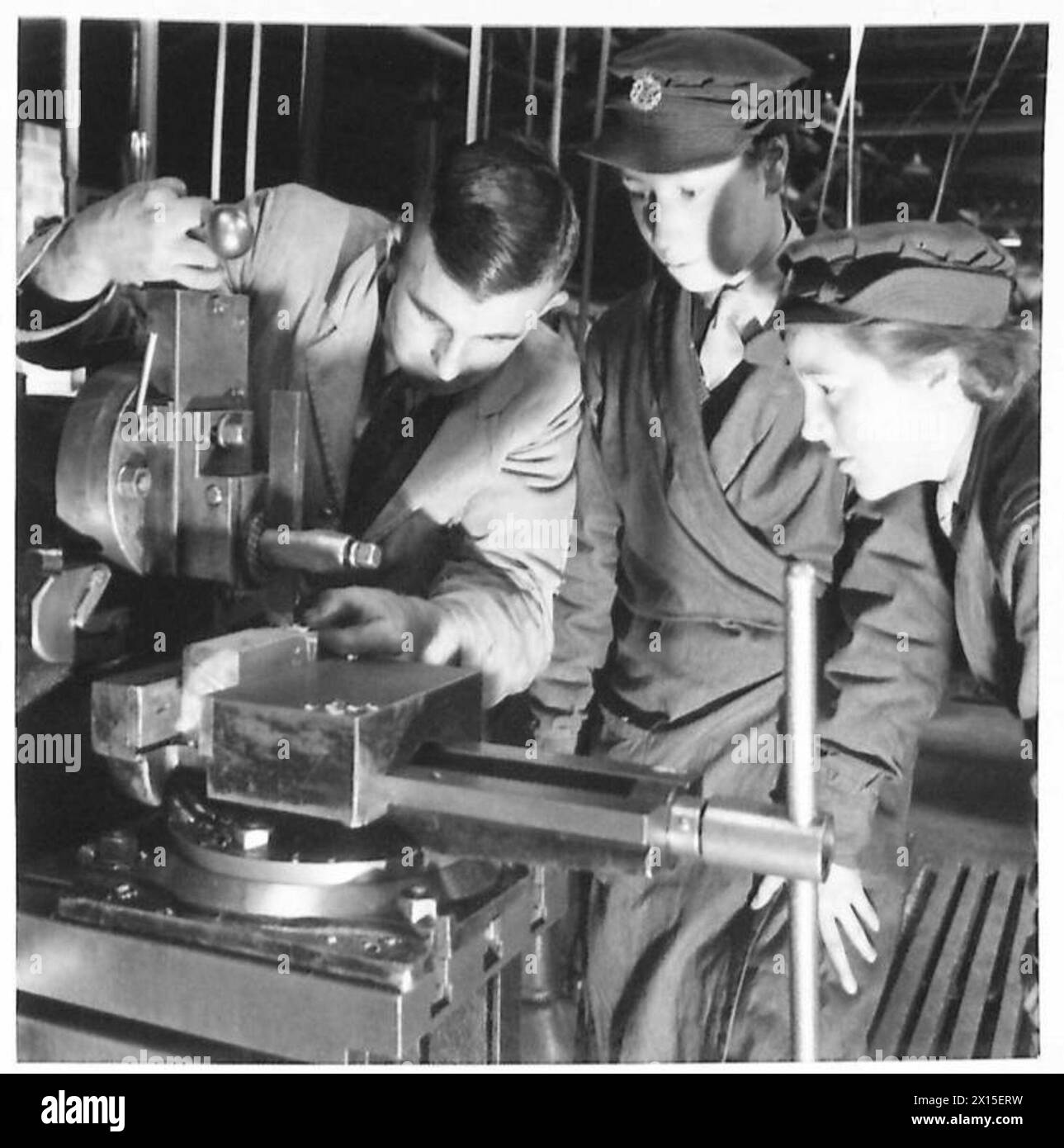 ATS ORDNANCE WORKERS - ATS at a Government Training Centre learn to be metal machinists. When trained they will be sent to REME Workshops and RAOC Depots, to mend tanks and lorries by making them new spare parts. Left : Pte. Capper, had had experience in a factory at Nelson Lancashire; right : Pte. Silvester was previously an inspector of jewesl. The machine they are learning to work is a Shaping machine, which cuts metal as with a chisel British Army Stock Photo