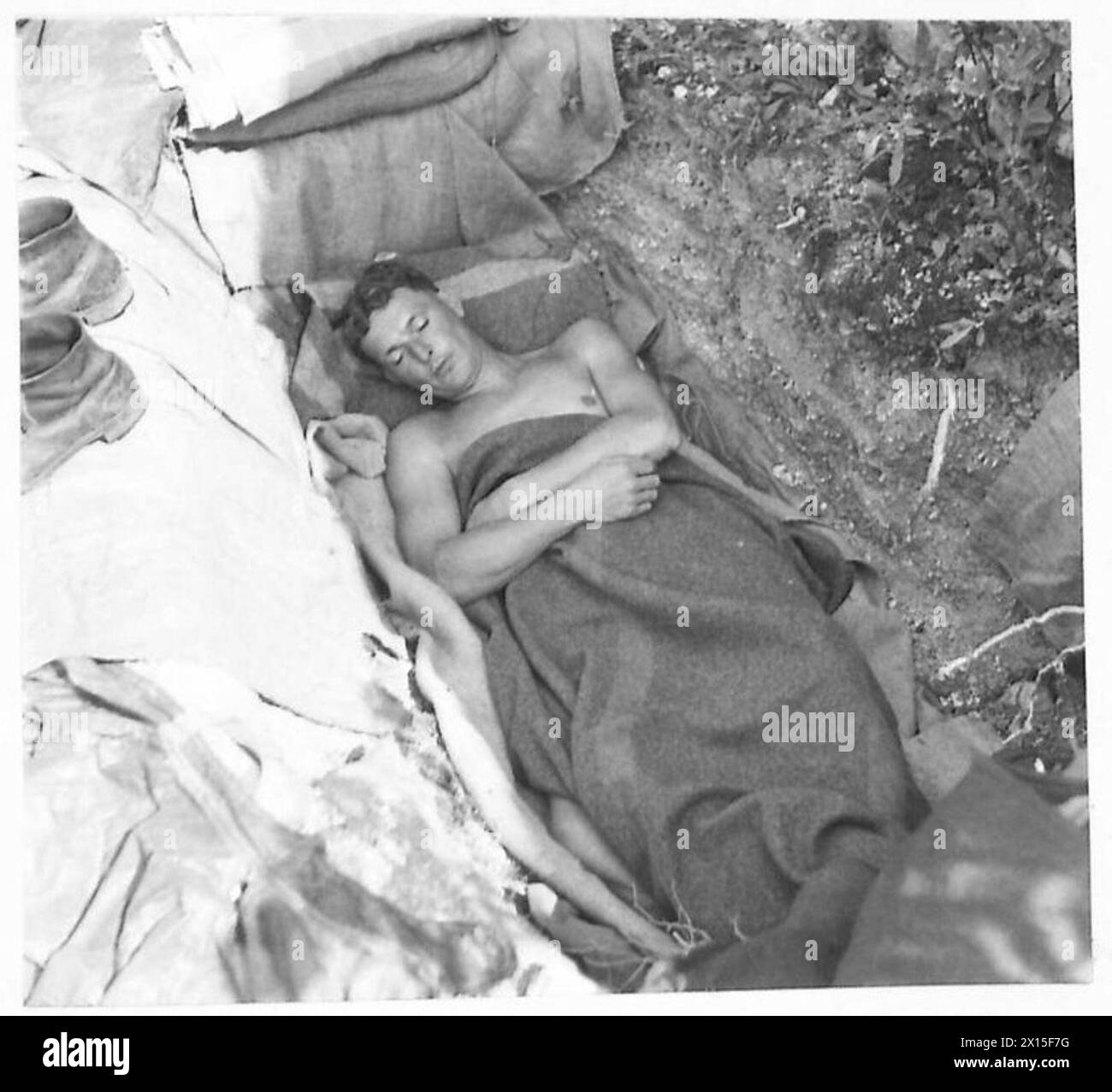 Gunner R. Rosser of the British Army's Eighth Army rests during daylight after nearly 14 hours of continuous firing in the assault on the Gustav Line. Stock Photo