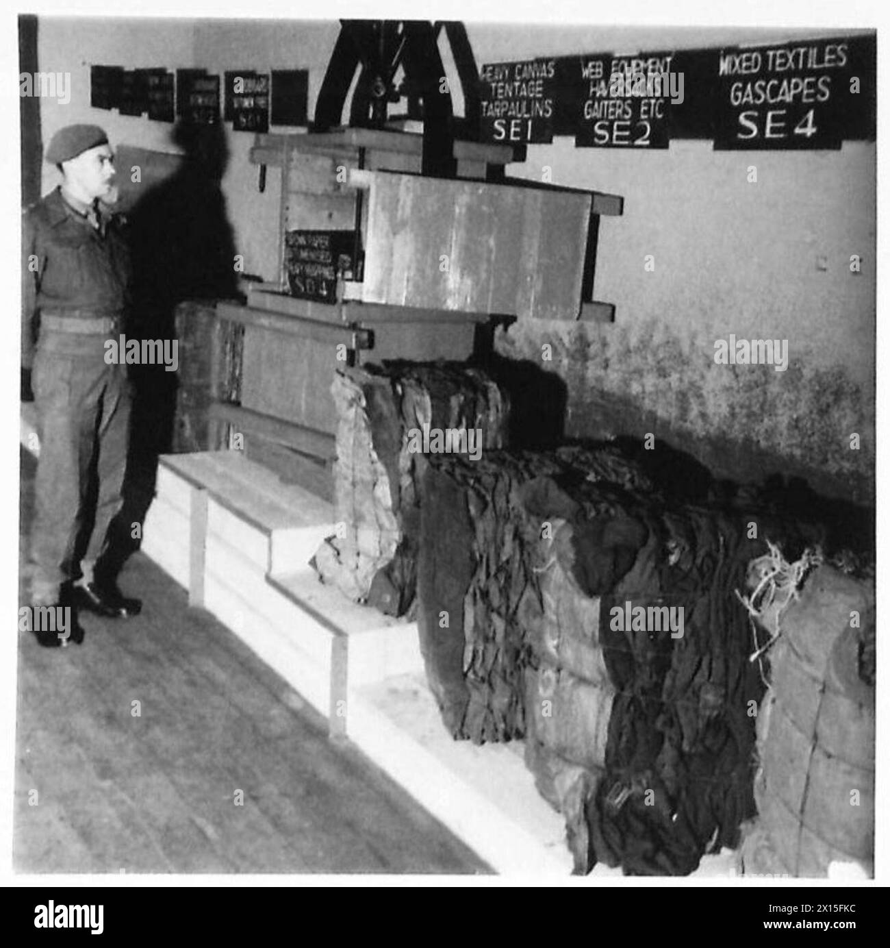 SALVAGE - The baling machine is made on the premises from scrap, old gas capes and cloths are in the bales British Army, 21st Army Group Stock Photo
