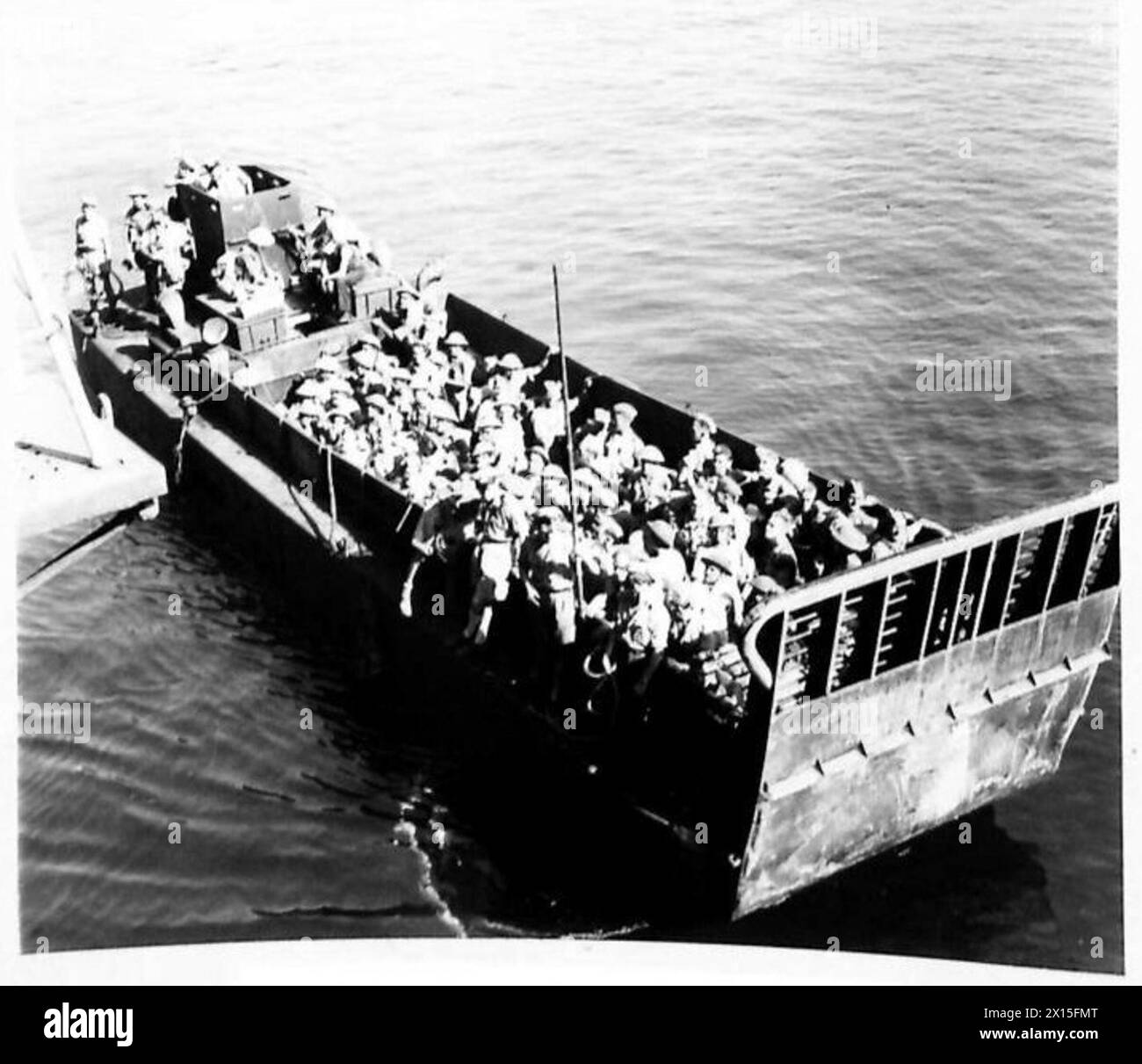 An L.C.M. landing craft loaded with troops approaches the shore in ...