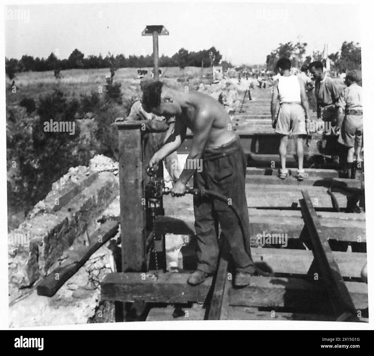 ITALY : EIGHTH ARMY : RAILWAY RECONSTRUCTION - Sapper Raymond Akers of 3, Parkside, Darlington, Co.Durham, drilling sleepers on the bridge British Army Stock Photo