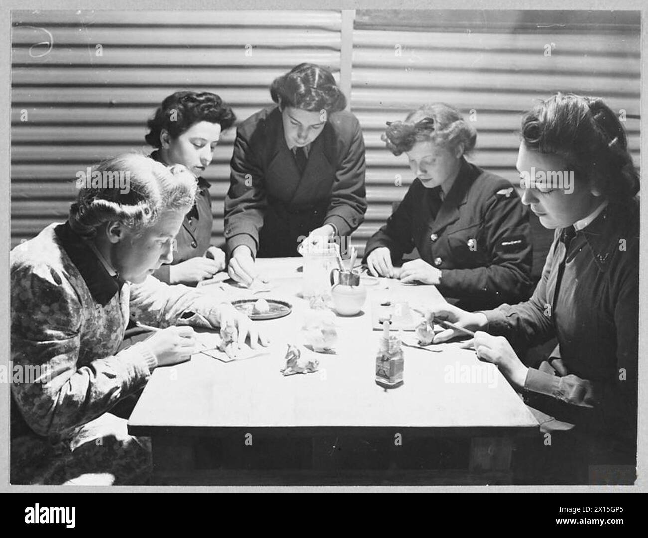 W.A.A.F. IN SCOTLAND : - 12188 Picture (issued 1944) shows - W.A.A.F. making clay models for the exhibition. Left to right - Section Officer Joan Cartright of Brighton; Corporal C.M.Wilson of Selkirk, Section Officer Helen Thornton of Edinburgh - the instructor [standing]; Leading Aircraftwoman Pennycock of Edinburgh, and Leading Aircraftwoman L.Phillip of Edinburgh Royal Air Force Stock Photo