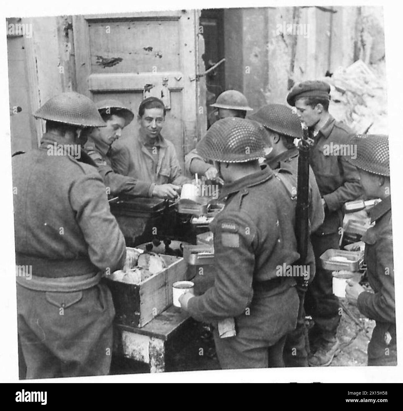 ITALY : EIGHTH ARMY ORTONA AFTER THE FIGHTING - Men of the 49 Edmonton Regiment have sited their cookhouse in what was once a fashionable shopping centre of Ortona. Some of the men are there taking a well-deserved meal British Army Stock Photo