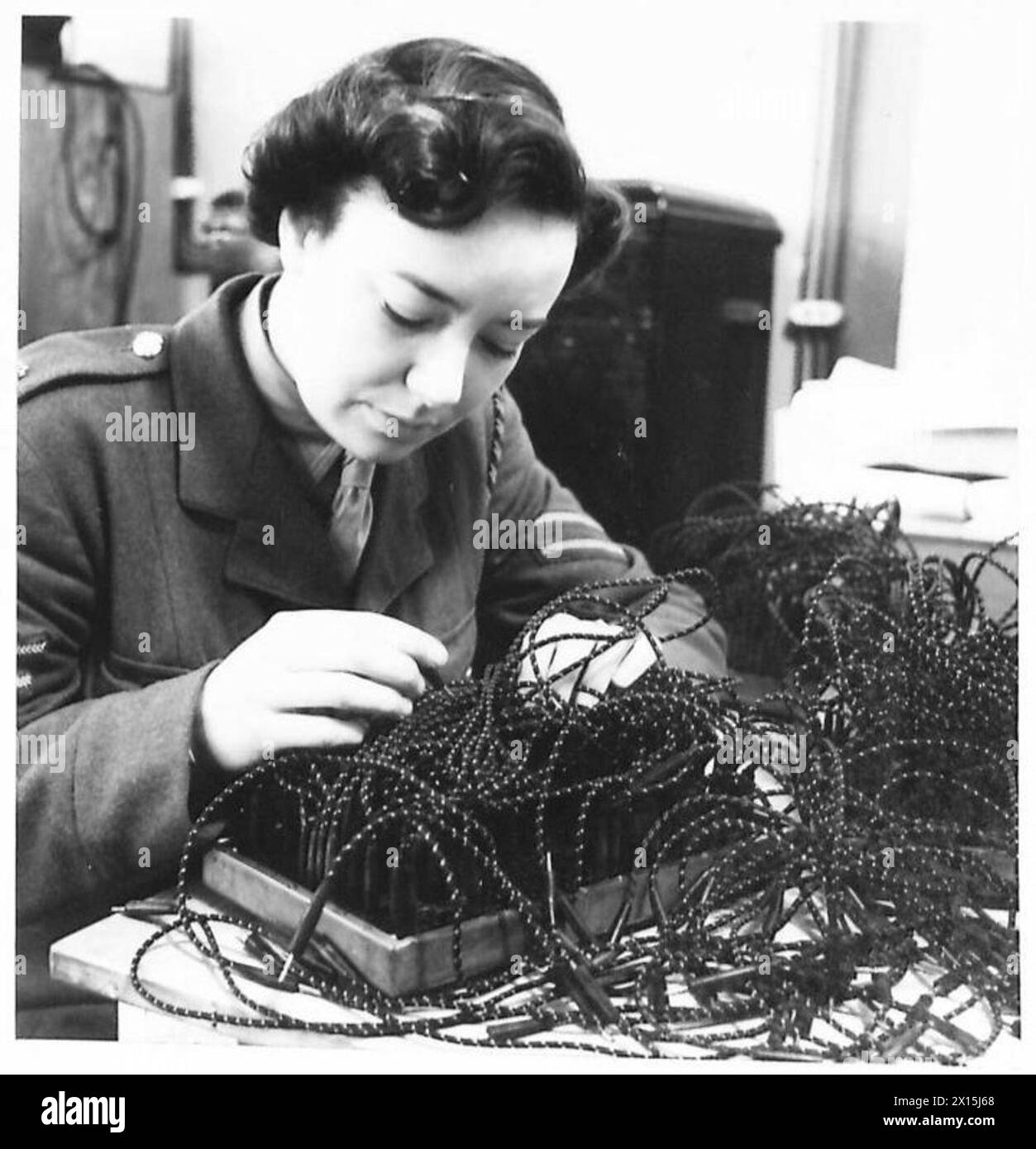 ATS STATISTIC OPERATORS - Cpl. Freda Hinton, one of the most highly skilled ATS operators, wires a tabulating machine. The arrangement of the plugs determines which columns of the punched cards are reproduced in the printed table. Mrs. Hinton has had five years civilian experiences of similar work in her home of Birkenhead. Her husband is serving in the Army overseas British Army Stock Photo
