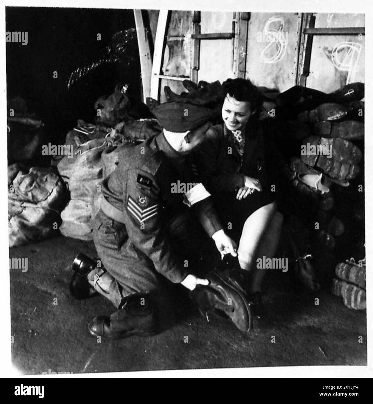 ROYAL ARMY ORDANANCE CORPS RETURNED STORES DEPOT - A comparison of footwear. Sergeant Rowe of Pembroke Docks, South Wales, compares the size of a woman worker's shoe with that of a soldiers British Army Stock Photo