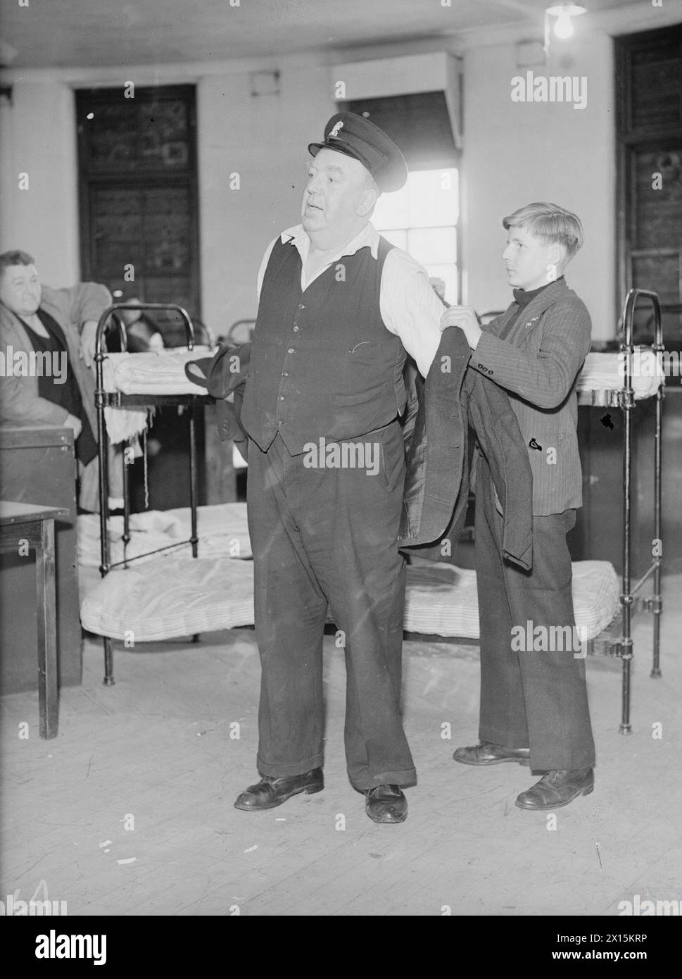 'OWD BOB' GOES TO SEA. 9 JUNE 1942, LIVERPOOL. ROBERT 'OWD BOB' DALY, WHO JOINED THE NAVY AT THE AGE OF 62 TO SERVE IN AUXILIARY WAR VESSELS UNDER SPECIAL AGREEMENT. - 'Owd Bob' trying on his naval uniform with a helping hand from Tommy Harding Stock Photo