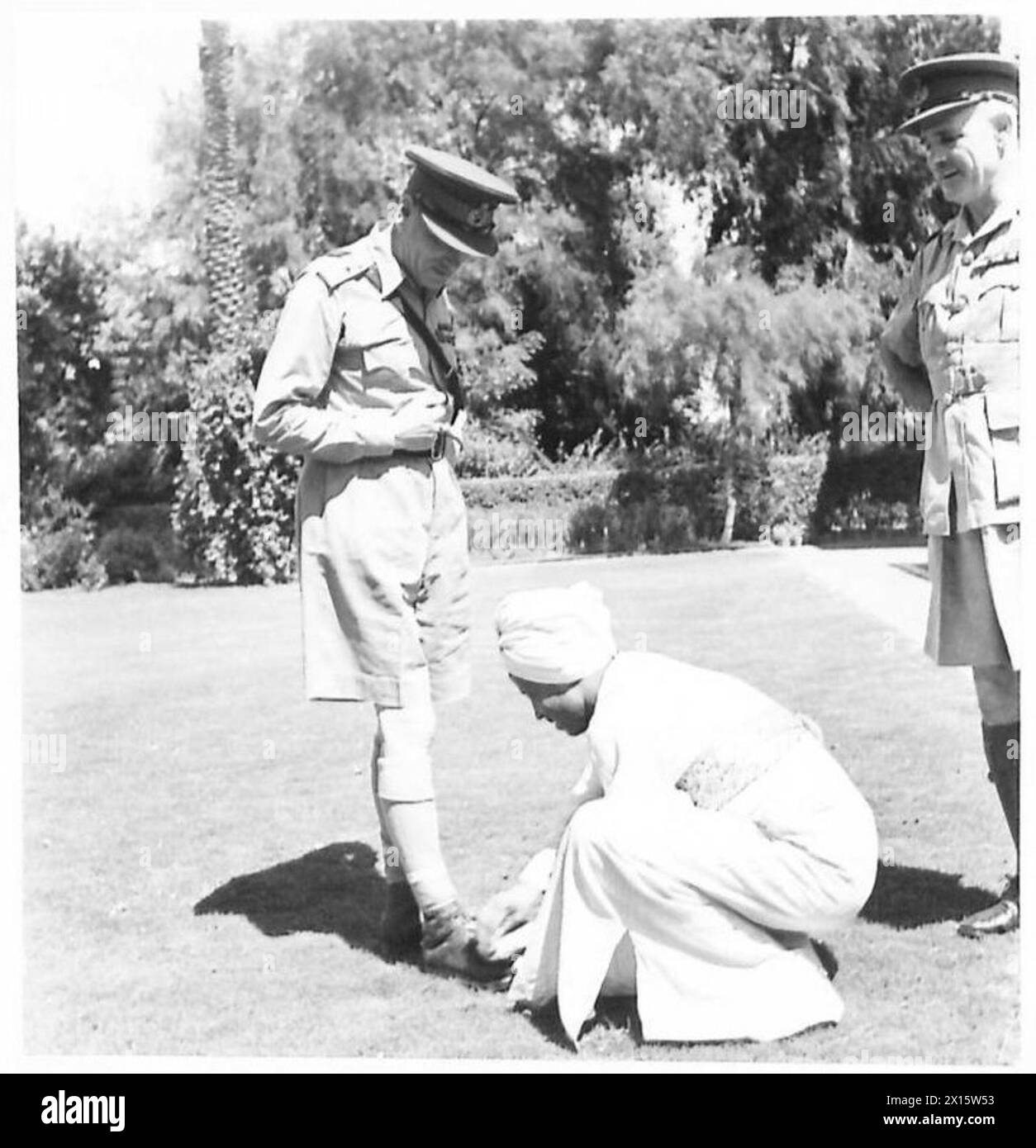 TWO WAR CHIEFS MEET - General Sir Claude Auchinleck, having arrived from the desert, has his shoes brushed over by a native servant British Army Stock Photo