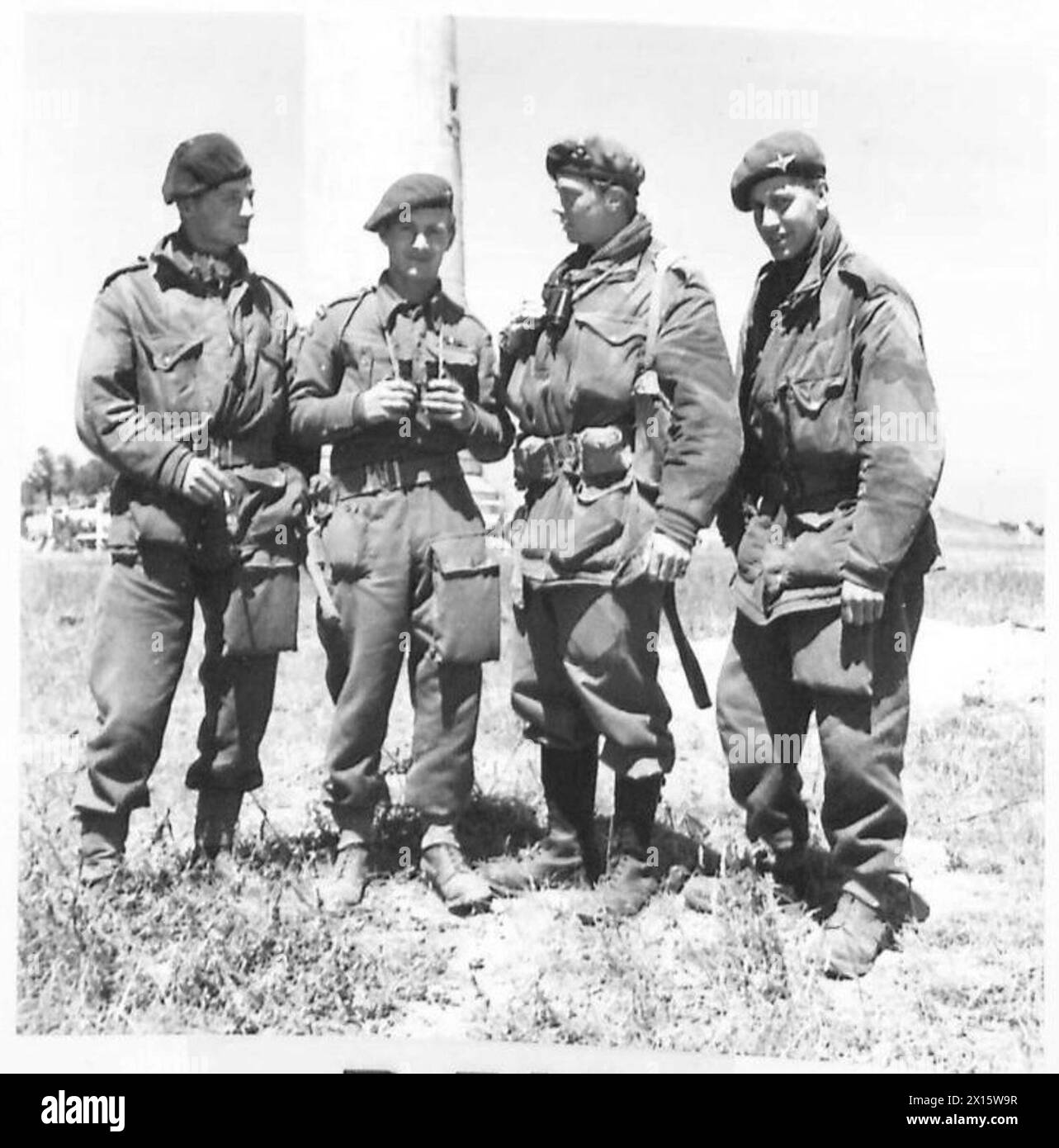 WITH A COMBINED OPERATIONS BOMBARDMENT UNIT - Members of a 'watch' coming off duty. Left to right:- Telegraphist W. Fortune of 22 Wood Street, Middlestone Moor, Nr. Spennymoor, Co.Durham, who landed on 'D' Day by parachute; Telegraphist A. J. Boomer, DSM; Captain F. Vere Hodge, MC,Huntspill, Highbridge, Somerset, and Telegraphist K. F. Moles of 112 Stortford Road, Rye Park, Hoddesdon, Herts British Army, 21st Army Group Stock Photo