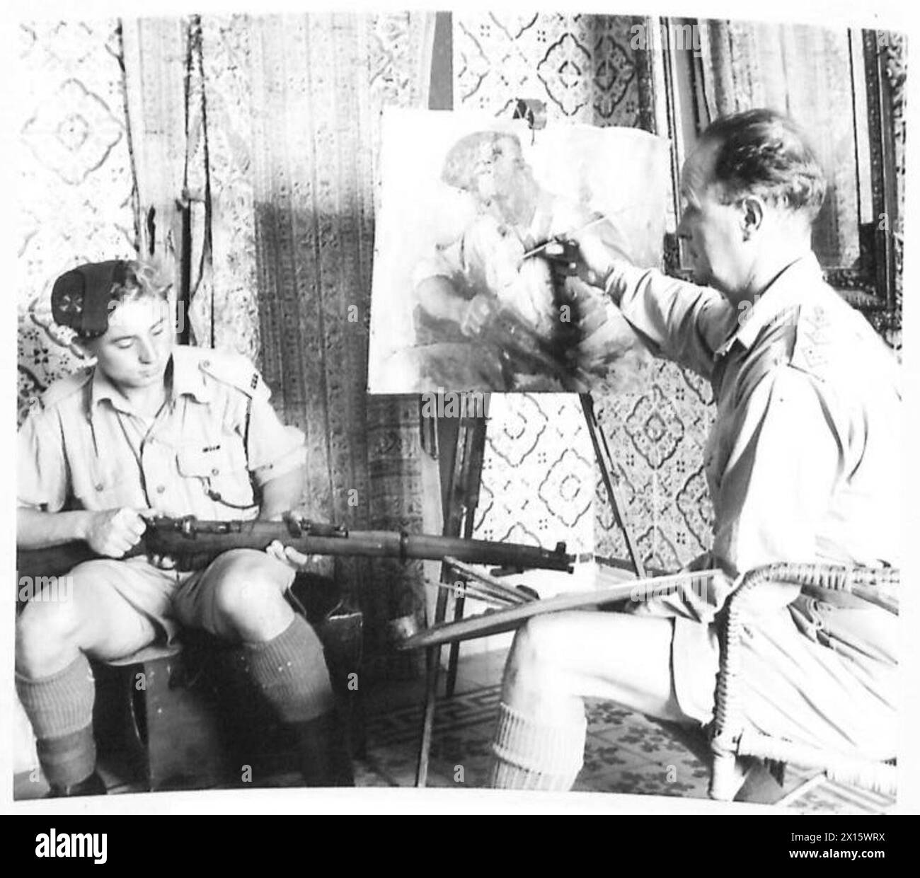 WAR ARTIST AT WORK IN NORTH AFRICA - Capt. H.M. Carr, Official War Artist at work on his painting of 6852209 Rifleman Bertus Russell Hill, MM of the lsy Bn. K.R.R.C. who resides at The Chelm Tree, 8, Slades Hill, Enfield, Middx British Army Stock Photo