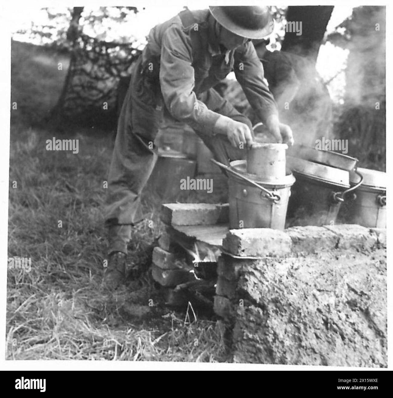WITH THE RASC AT CRYSTAL PALACE - A trench fire being used by a cook to boil puddings , British Army Stock Photo