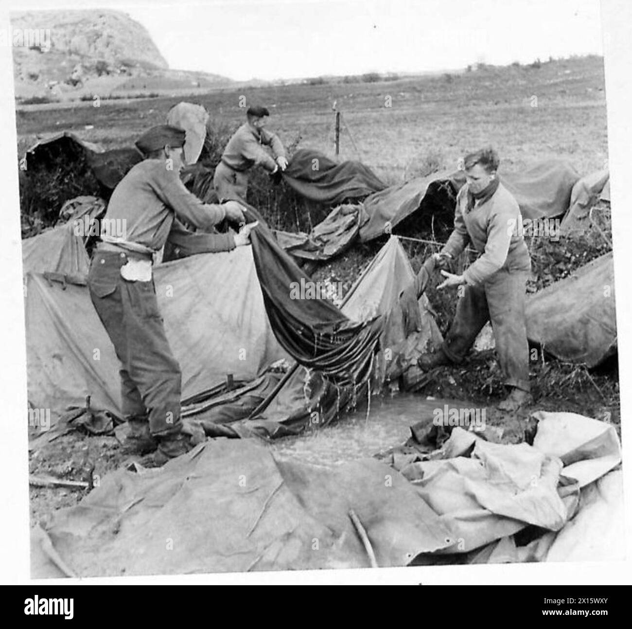 ITALY : FIFTH ARMY'AFTER THE STORM' - Sgt. J. Hamilton of Biggar, Lanarkshire, Scotland, and Gnr. H. Tennant of Lanark, Scotland, retrieve a blanket from a waterlogged tent British Army Stock Photo