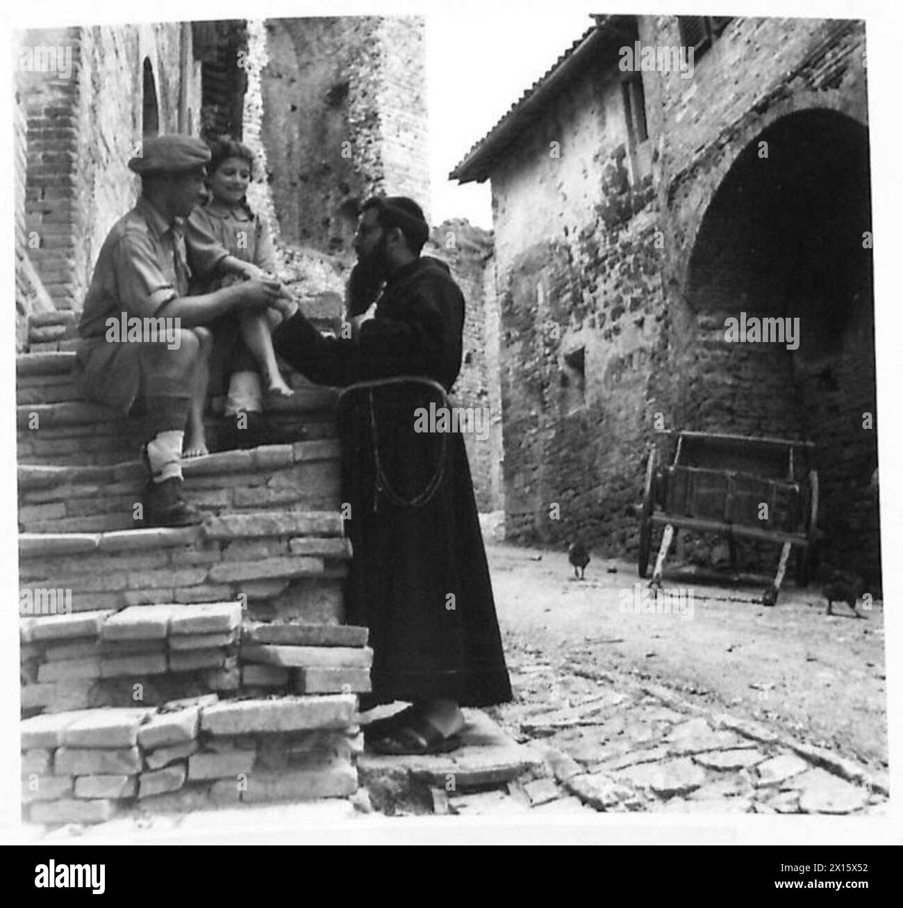 EIGHTH ARMY - A Holy Father greets a local child, who has already made the acquaintance of a British Tommy. The soldier is:- Gnr. W. Stower, 96 Rosebery Avenue, Tottenham, London, N.17 British Army Stock Photo