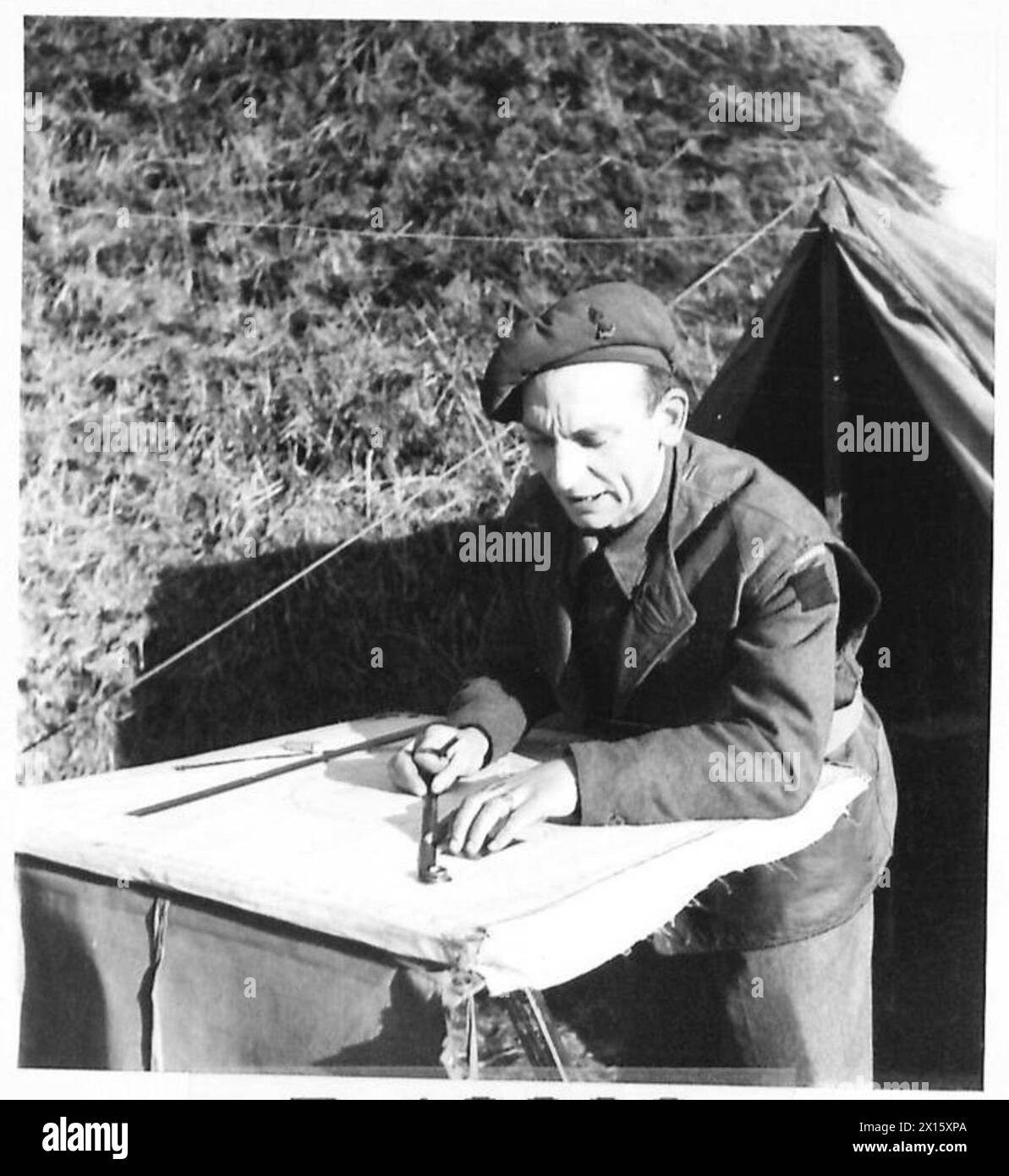 Gun Position Officer's assistant, Gnr. E. Lockett, conducts plotting to ...