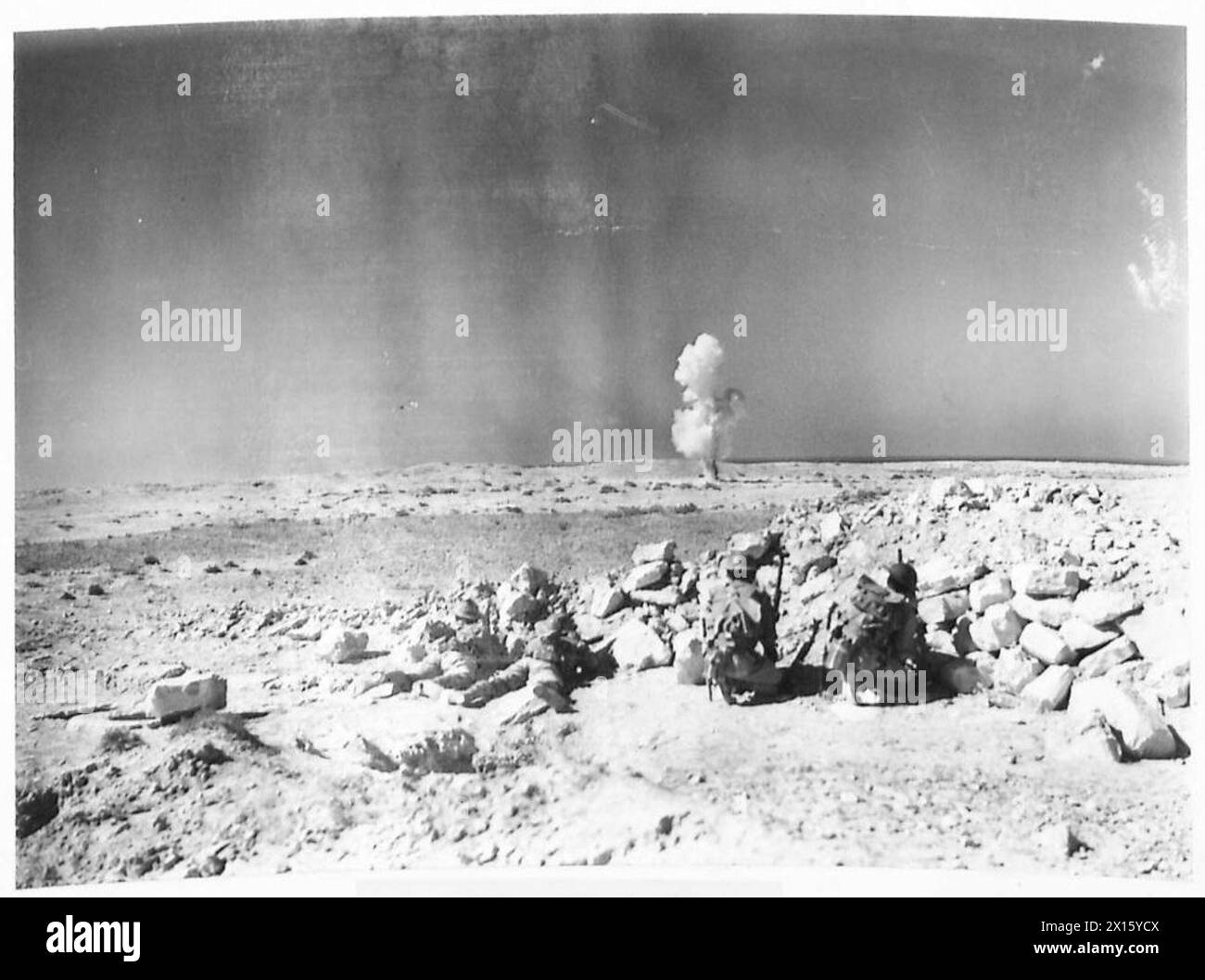 PHOTOGRAPHS OF AN INDIAN DIVISION IN THE WESTERN DESERT - Miners and Sappers of an Indian Division exploding an Italian bomb that failed to explode when dropped. Gelignite was placed next to the bomb and the bomb exploded British Army Stock Photo