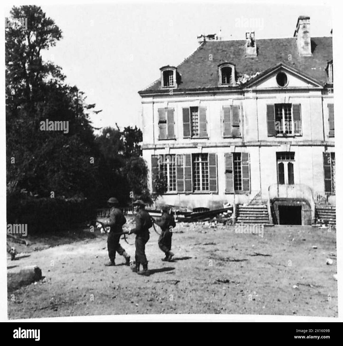 THE ADVANCE TOWARDS VILLERS BOCAGE - Infantrymen searching the grounds of a large chateau near Villy Bocage. The Germans had been using the building as a hospital and our troops were looking for possible snipers and prisoners.Identified as Chateau du Haut Fecq, in Monts-en-Bessin British Army, 21st Army Group Stock Photo