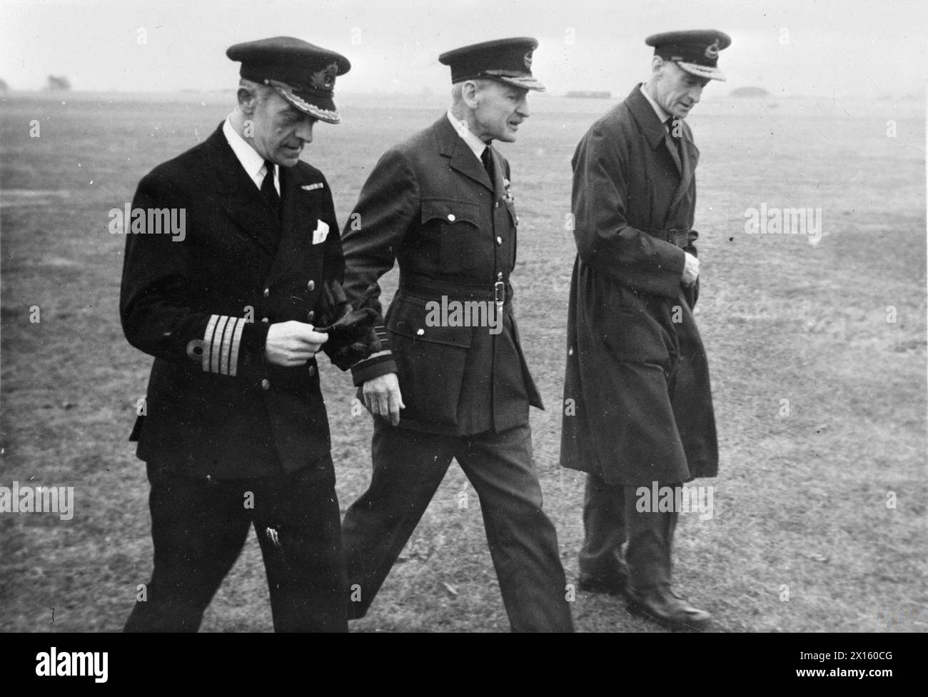 AIR CHIEF MARSHAL VISITS ATC AT ROYAL NAVAL AIR STATION. AUGUST 1944, ROYAL NAVAL AIR STATION YEOVILTON. THE VISIT OF AIR CHIEF MARSHAL SIR ROBERT BROOK POPHAM, GCVO, TO INSPECT MEMBERS OF THE ATC IN CAMP AT YEOVILTON. - The Air Chief Marshal (centre) accompanied by Captain C L Keighly-Peach, DSO, OBE, RN (left) and Air Commodore Smythe-Osborne, AOC South West Command ATC on their way to inspect the ATC Stock Photo