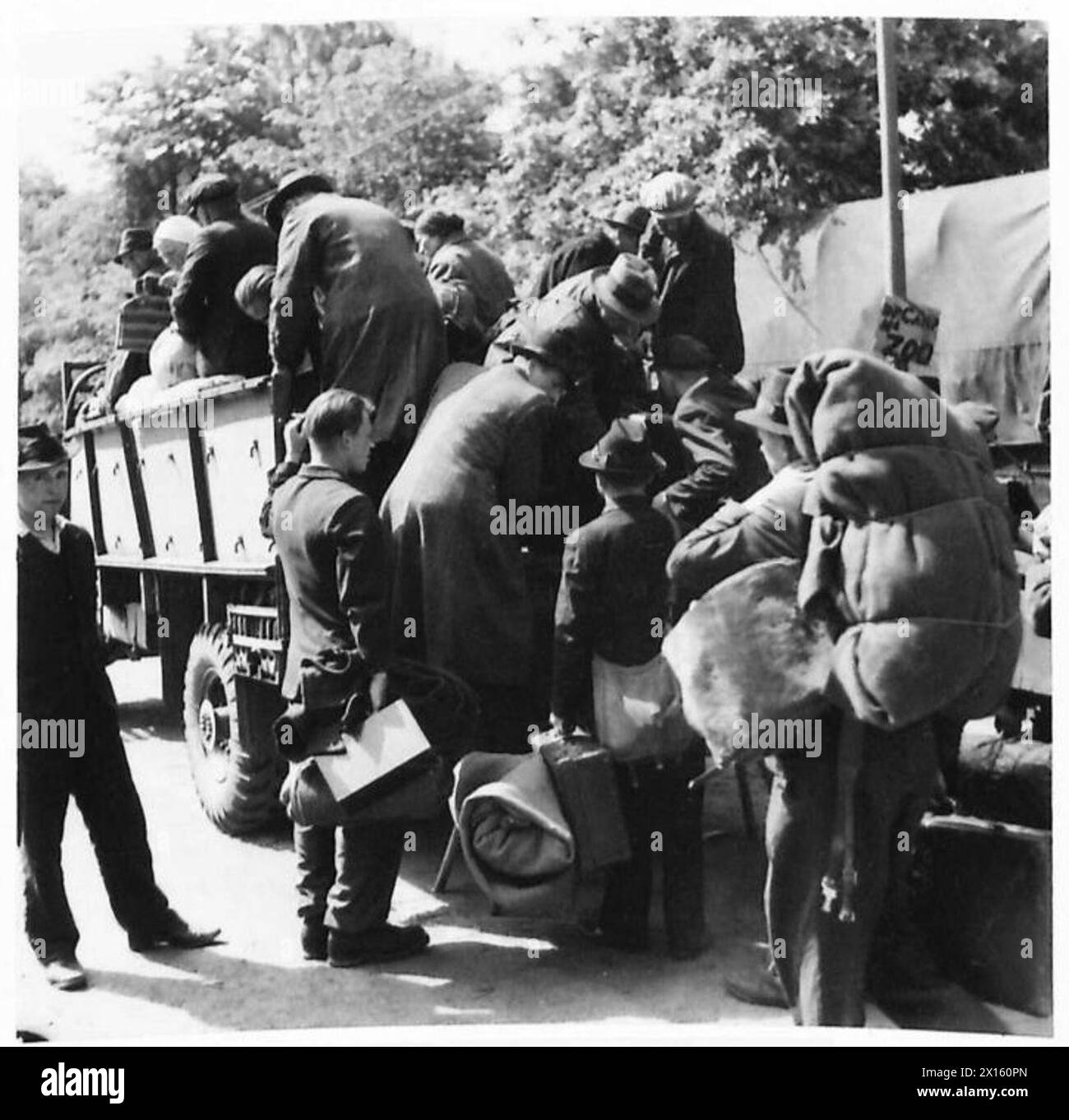 DISPLACED PERSONS AND REFUGEES IN GERMANY - Polish nationals boarding army lorries to take them from No.17 Displaced Persons Assembly Centre at Hamburg Zoological Gardens to a Polish national camp for repatriation. The Displaced Persons camp within the grounds of Hamburg Zoo was build by the Blohm & Voss company during WWII to house the forced labourers that worked in their factory. The camp was taken over by the British on 5 May 1945 and quickly given over as an arrivals centre for displaced persons. On arrival displaced persons were organised into groups of 50 for processing through the rece Stock Photo