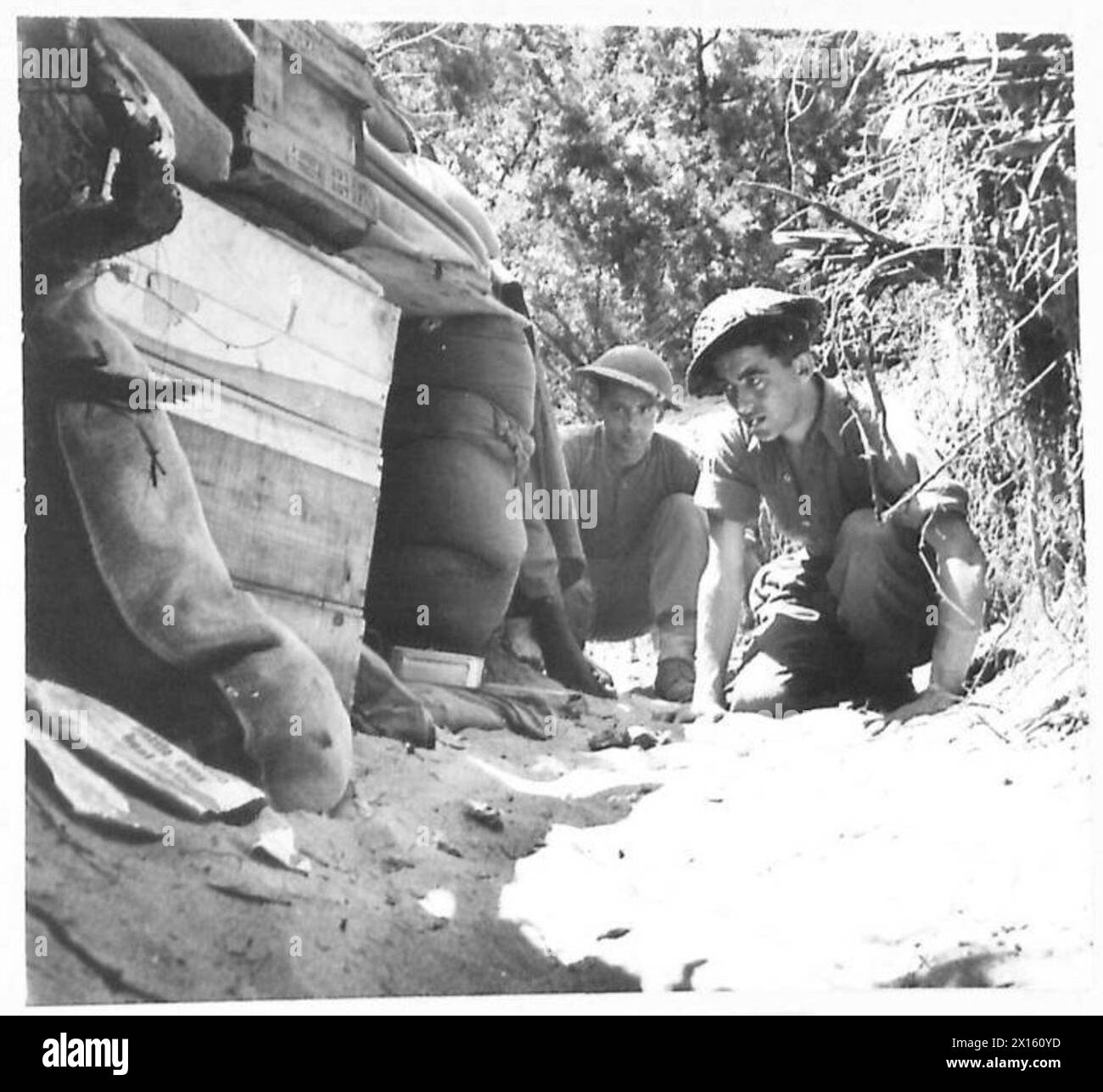 FIFTH ARMY - ANZIO BRIDGEHEAD (VARIOUS) - Half-way along the communication trench to the 131 Section O.P. is a small dugout occupied day and night by reliefs. Two of the reliefs are seen returning from their midday meal. They are:- Pte. H. Welch (nearest camera) of 21 Spencer Street, St.Hamos End, Northampton, and Pte. B. Stapenhurst of 81, Hampstead Way, London, N.W.11 British Army Stock Photo
