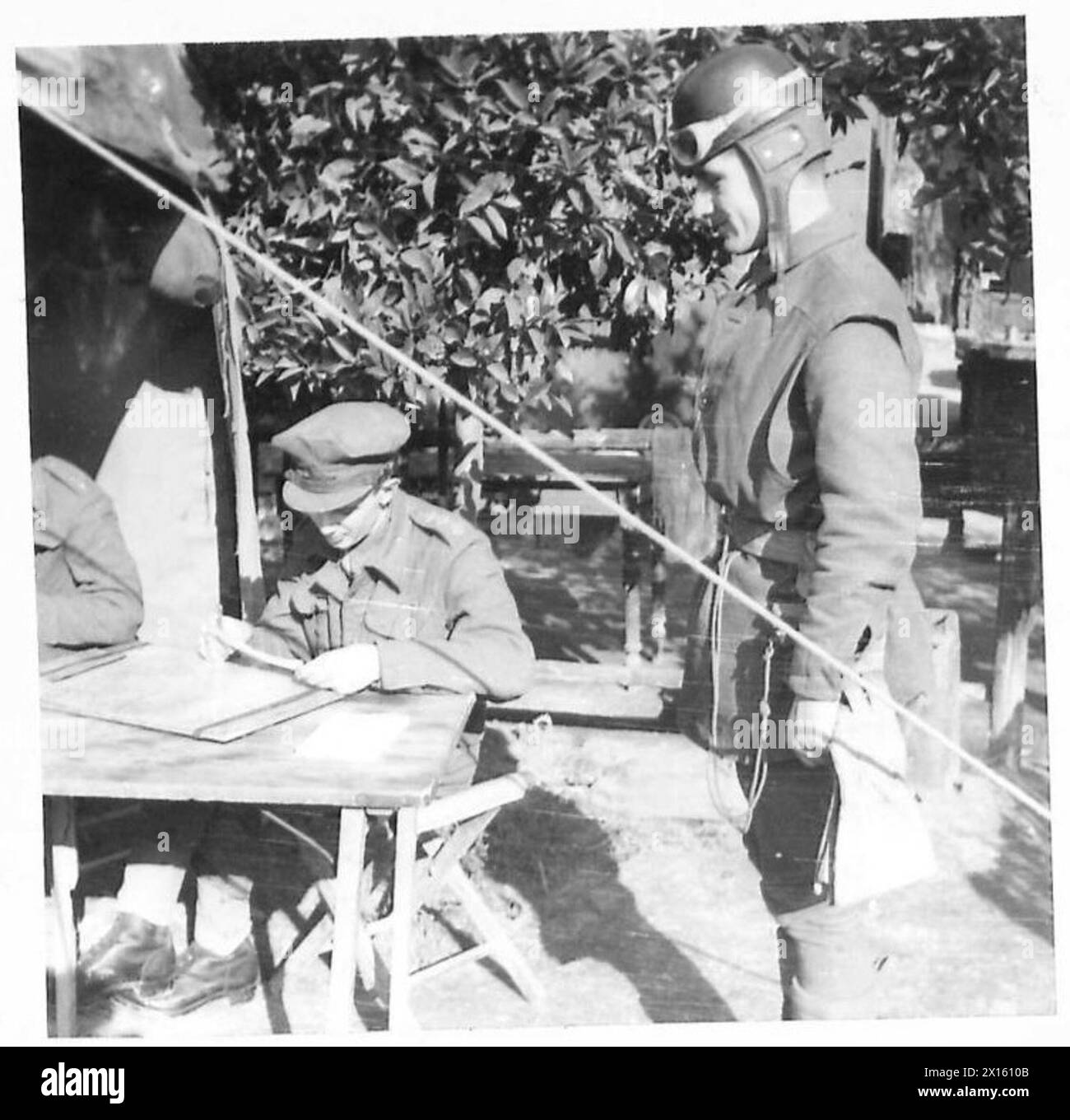 ITALY : FIFTH ARMYARTILLERY SURVEY IN ACTION - D.R. Gnr. T. Grant arrives from HQ with a message which he hands to Capt. Warner at the Survey Report Centre. It is a request to make a reconnaissance survey of a new gun area for the correct placing of the artillery moving in British Army Stock Photo
