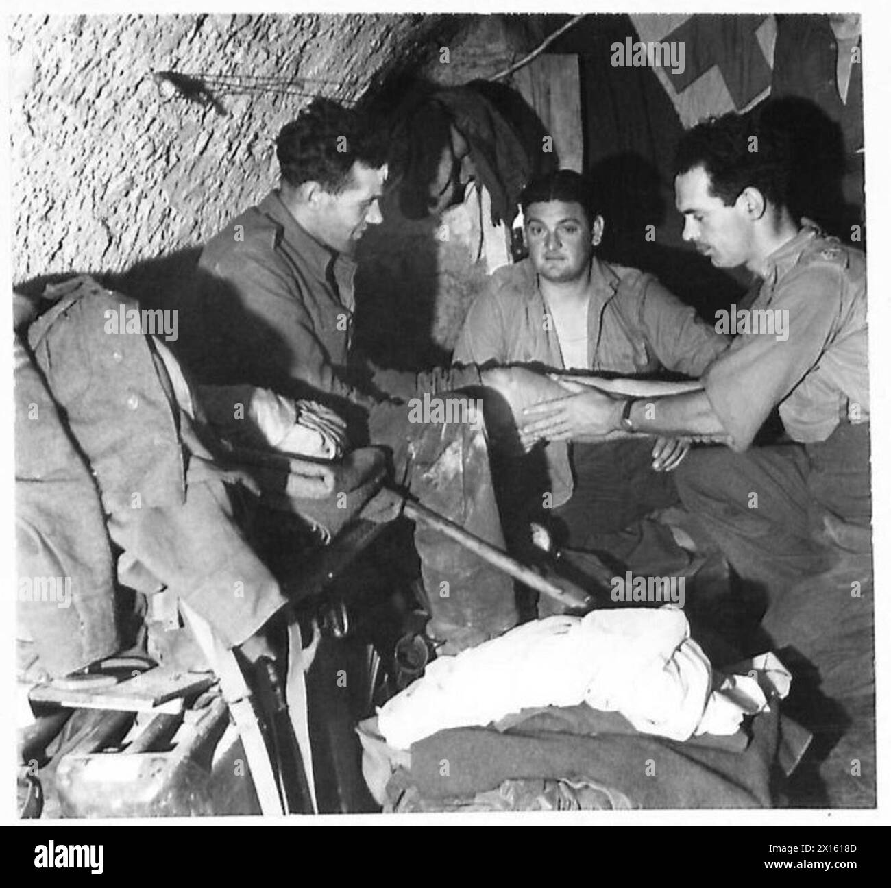 UNDERGROUND CONTROL - Capt. Brodie of Elgin, Scotland, the M.O., attends to the injuries of a Guardsman in the underground tunnels British Army Stock Photo