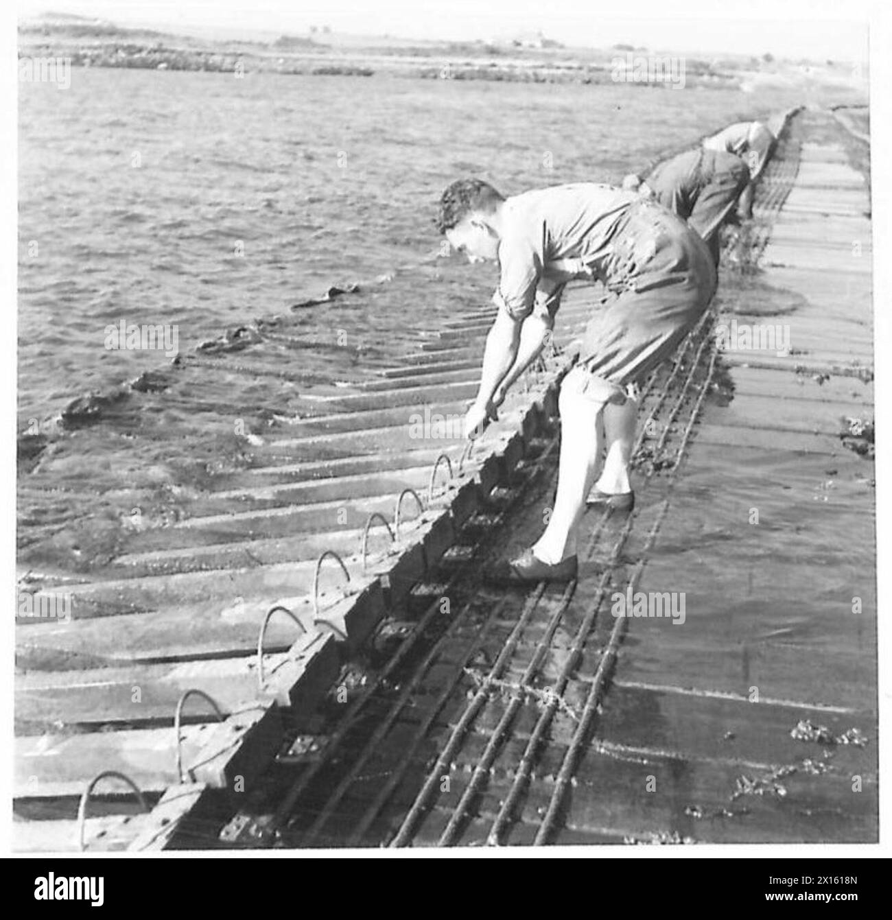 Personnel wire curb arms of Swiss Roll mat during a special assignment. Photographic record, British Army. Stock Photo
