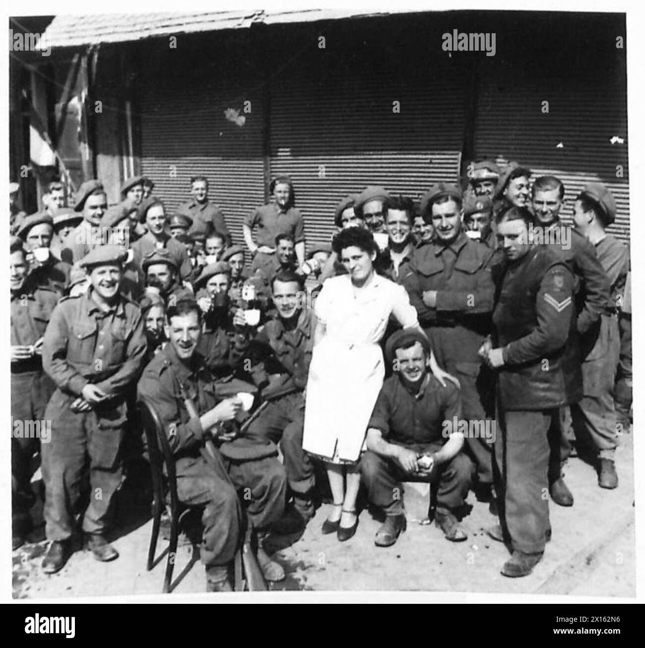 NORMANDY - VARIOUS - Some of the troops enjoying a cup of tea seated outside The Pop Inn Naafi canteen in Caen British Army, 21st Army Group Stock Photo