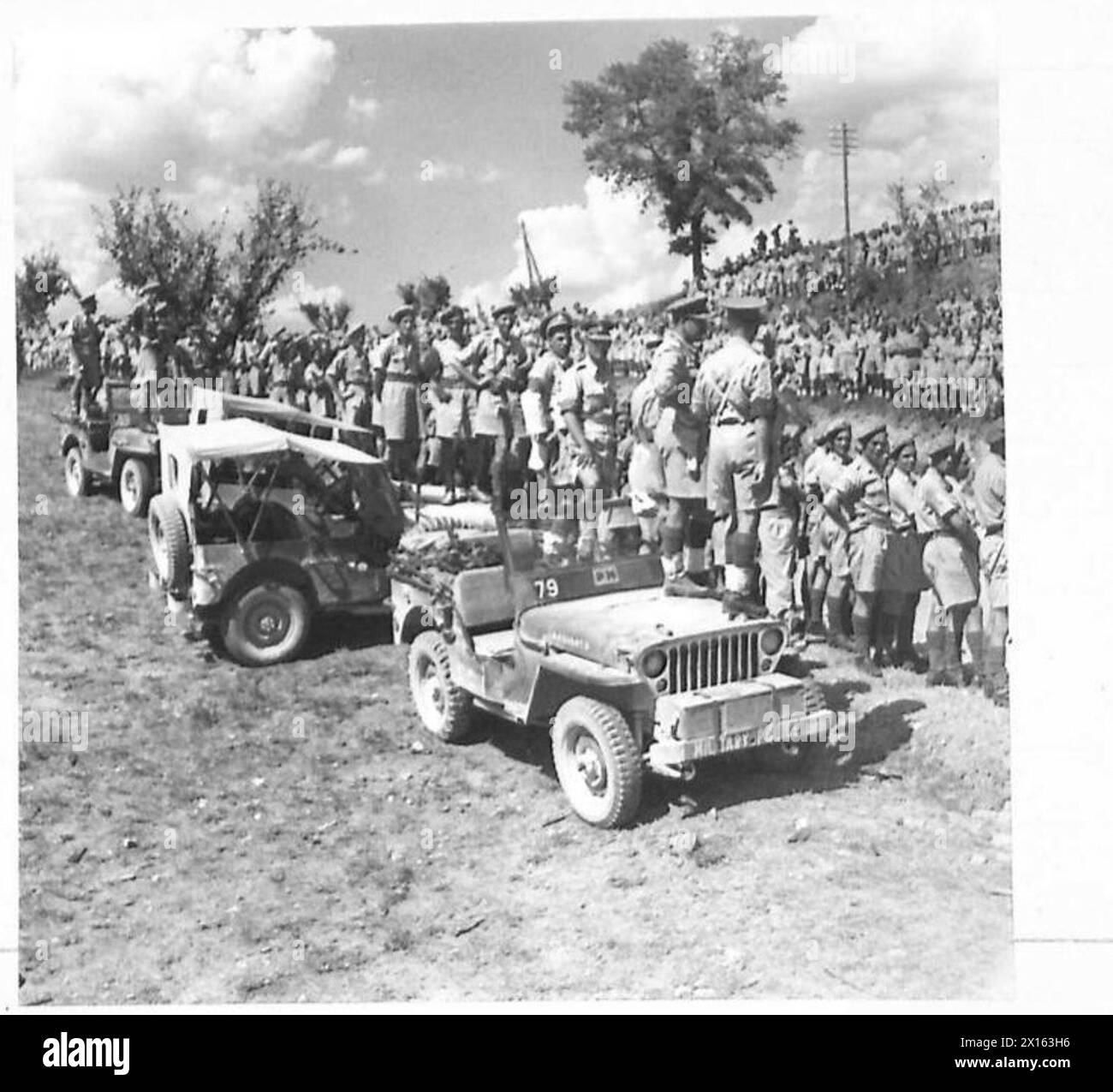 Troops line the roadside near Rosco, Italy, awaiting the visit of His Majesty the King to the British Eighth Army. Stock Photo