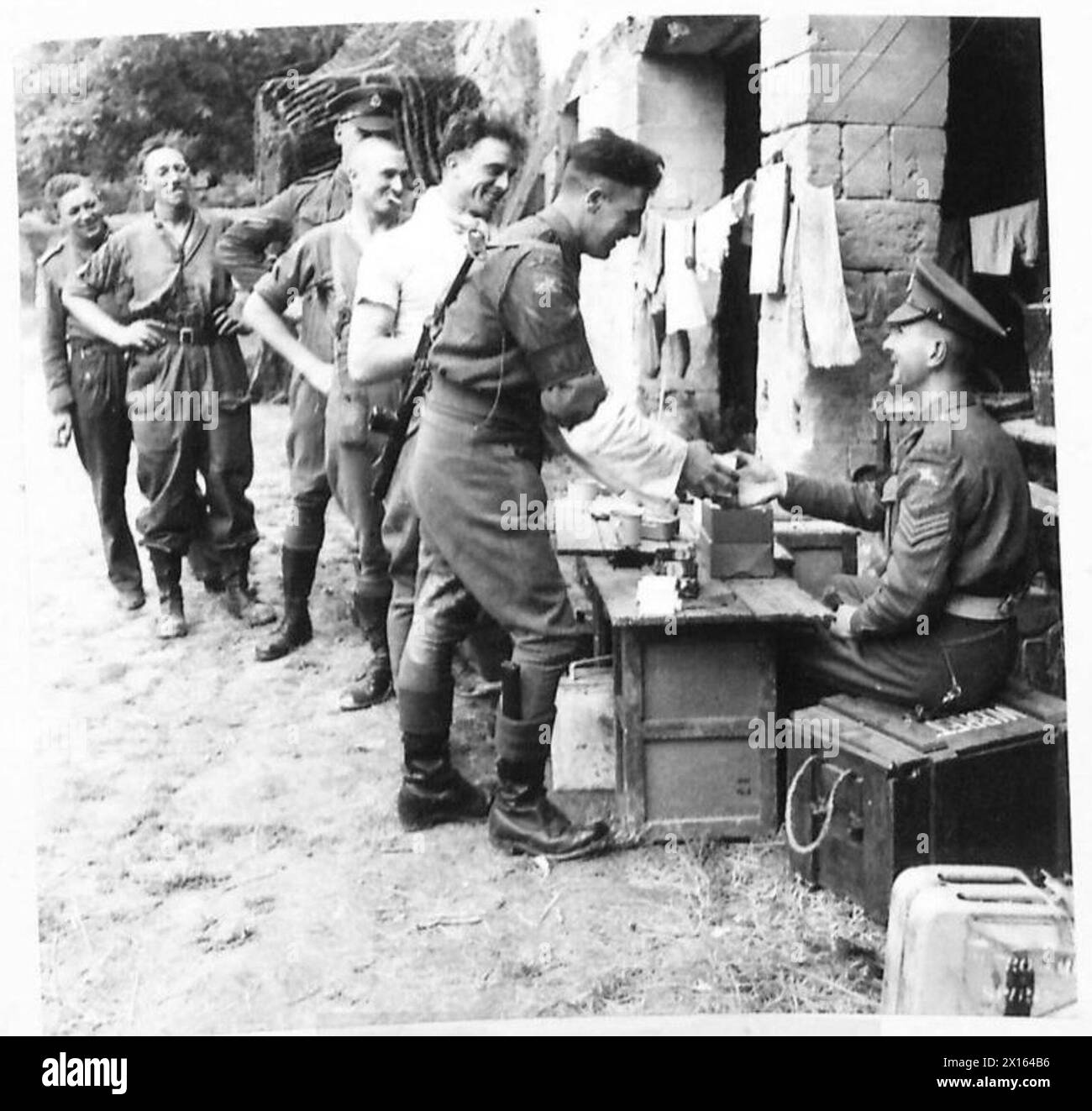 MILITARY POLICE IN FRANCE - Sergeant Brett of the Isle of Wight is seen issuing the NAAFI pack which has just arrived. It consists of 1 razor blade, 1 cake of soap and 50 cigarettes. 8th Corps, 110 CMP British Army, 21st Army Group Stock Photo