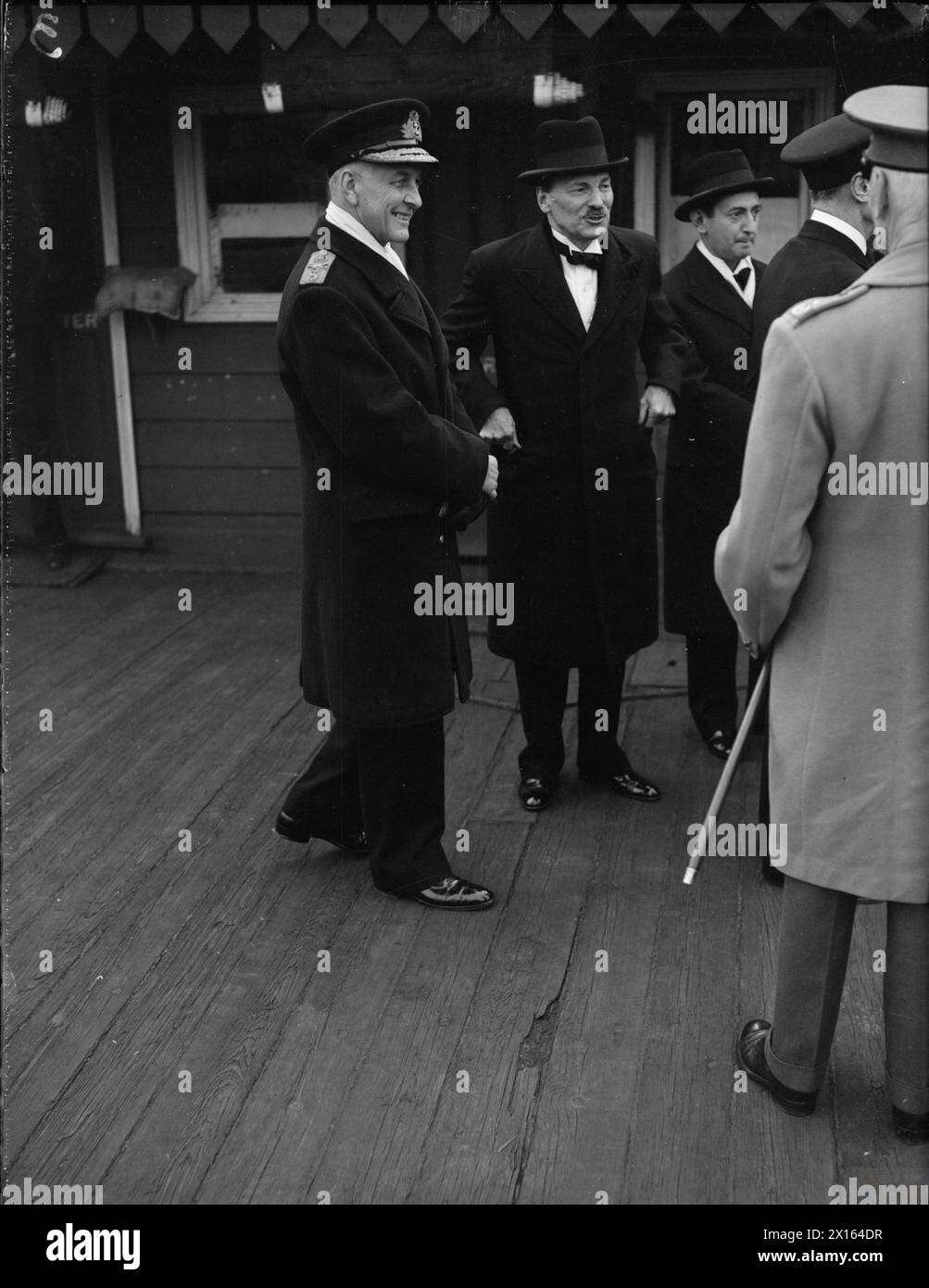 EMPIRE PREMIERS SAIL DOWN THE THAMES TO DINNER. 8 MAY 1944, WESTMINSTER PIER. EMPIRE PREMIERS LEAVING BY ML EN ROUTE FOR THE ROYAL NAVAL COLLEGE, GREENWICH, TO ATTEND THE DINNER GIVEN IN THEIR HONOUR BY THE BOARD OF ADMIRALTY. - Left to right: Vice Admiral Sir E Neville Syfret, KCB; Mr C Atlee; Sir Henry V Markham, KCB, MC; and Field Marshal Smuts (back to camera), at Westminster Pier Stock Photo