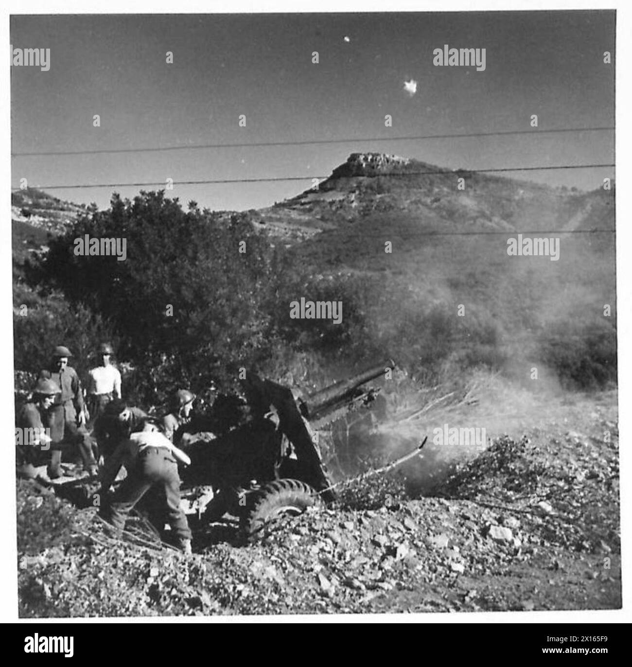 THE BRITISH ARMY IN THE TUNISIA CAMPAIGN, NOVEMBER 1942-MAY 1943 - A 25 pounder artillery gun of the Royal Artillery in action on the Djebel-Bargou front, 31 January 1943. Troops of the 6th Battalion, Queen's Own (Royal West Kent) Regiment (78th Infantry Division) arrived at Siliana (Djebel-Bargou Front) and moved through Robba to relieve a French unit in the line. They started to advance and continued to do so the following day. 'C' Company carried on the advance and maintained contact with the Italians and after a severe pounding by 25 pounder artillery guns the enemy again retreated and on Stock Photo
