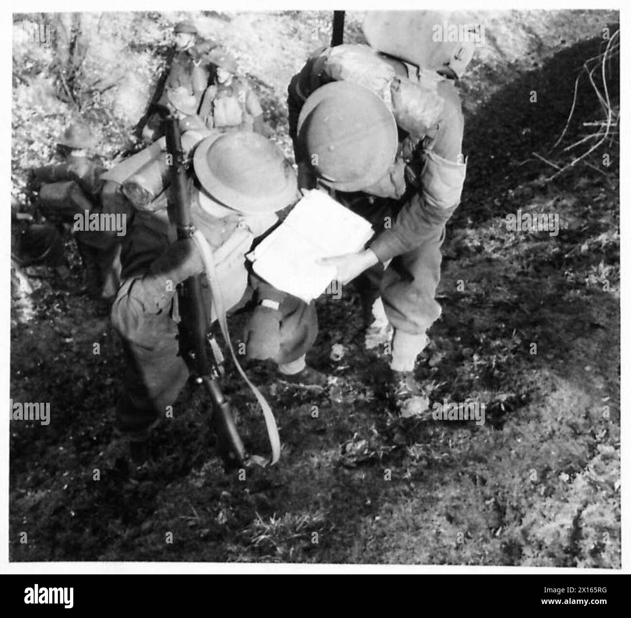 ROUNDING UP PARACHUTE TROOPS - A sergeant of the South Wales Borders consults his map whilst his section are resting by the side of a sunken road on the side of the South Downs at Chanctonbury Hill, Sussex, 4th Corps area British Army Stock Photo